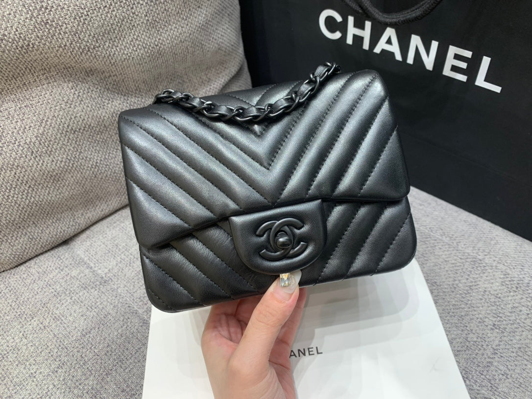 MINI BOLSO CUADRADO CON SOLAPA 17 CM PIEL DE CORDERO NEGRA CHEVRON HERRAJES NEGROS