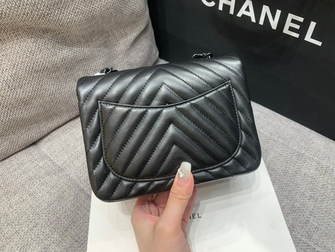 MINI BOLSO CUADRADO CON SOLAPA 17 CM PIEL DE CORDERO NEGRA CHEVRON HERRAJES NEGROS