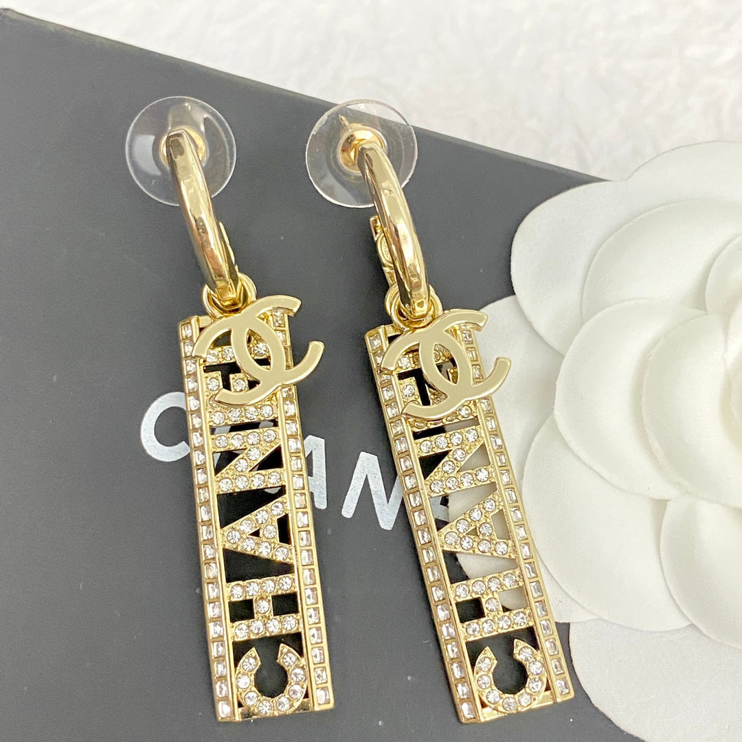 Boucles d'oreilles pendantes en or clair pavées de diamants avec texte CC