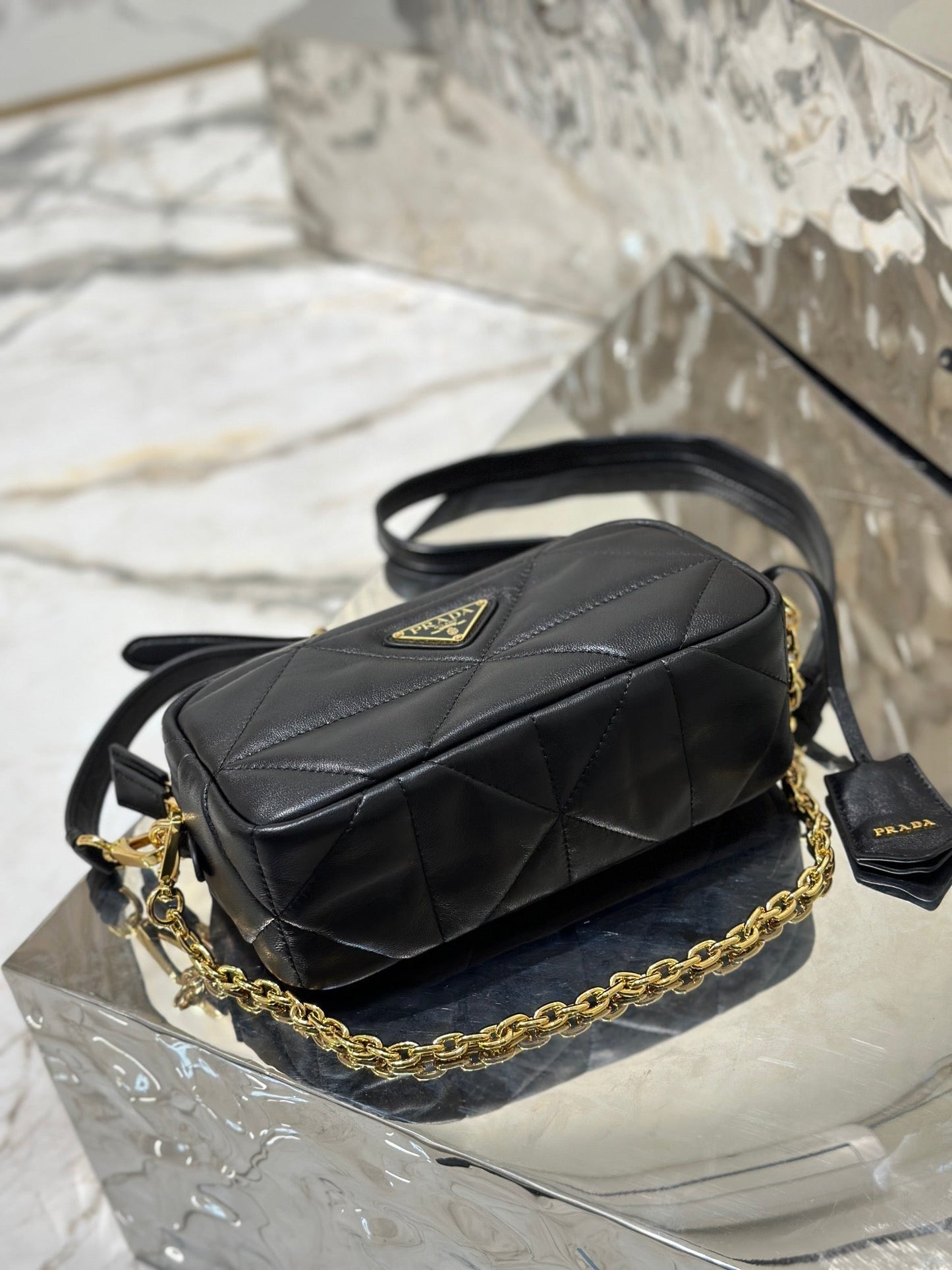 BOLSO PARA CÁMARA 22 EN PIEL DE CORDERO ACOLCHADA CON ESTAMPADO DE TRIÁNGULOS NEGROS Y HERRAJES DORADOS