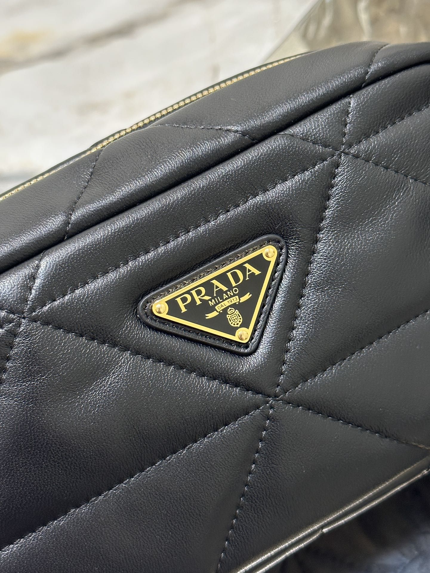 BOLSO PARA CÁMARA 22 EN PIEL DE CORDERO ACOLCHADA CON ESTAMPADO DE TRIÁNGULOS NEGROS Y HERRAJES DORADOS