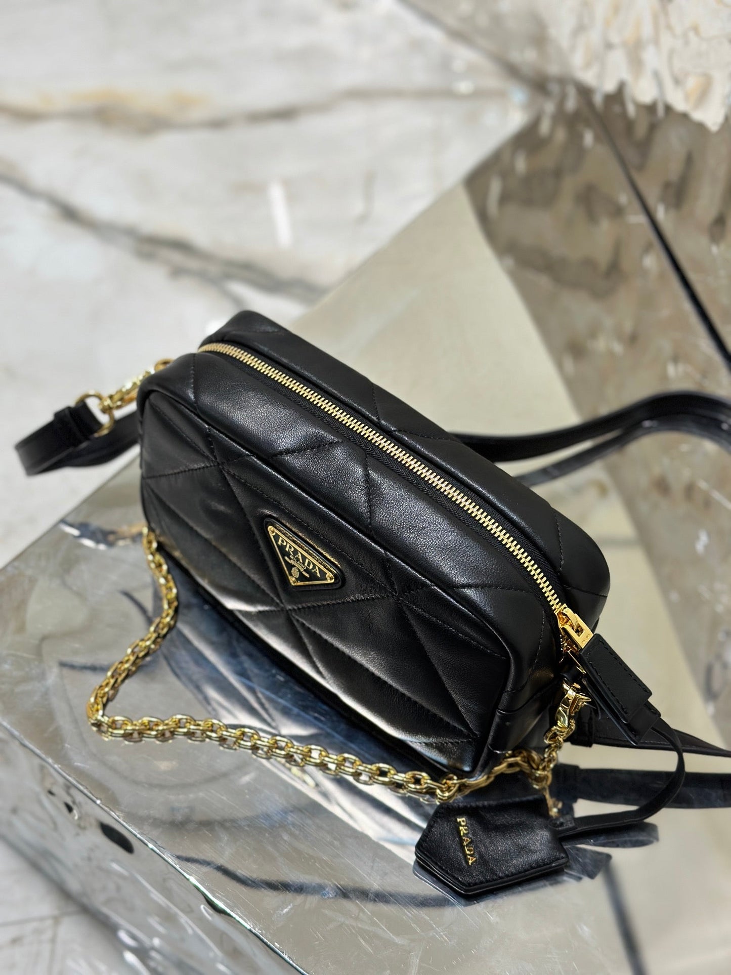 BOLSO PARA CÁMARA 22 EN PIEL DE CORDERO ACOLCHADA CON ESTAMPADO DE TRIÁNGULOS NEGROS Y HERRAJES DORADOS