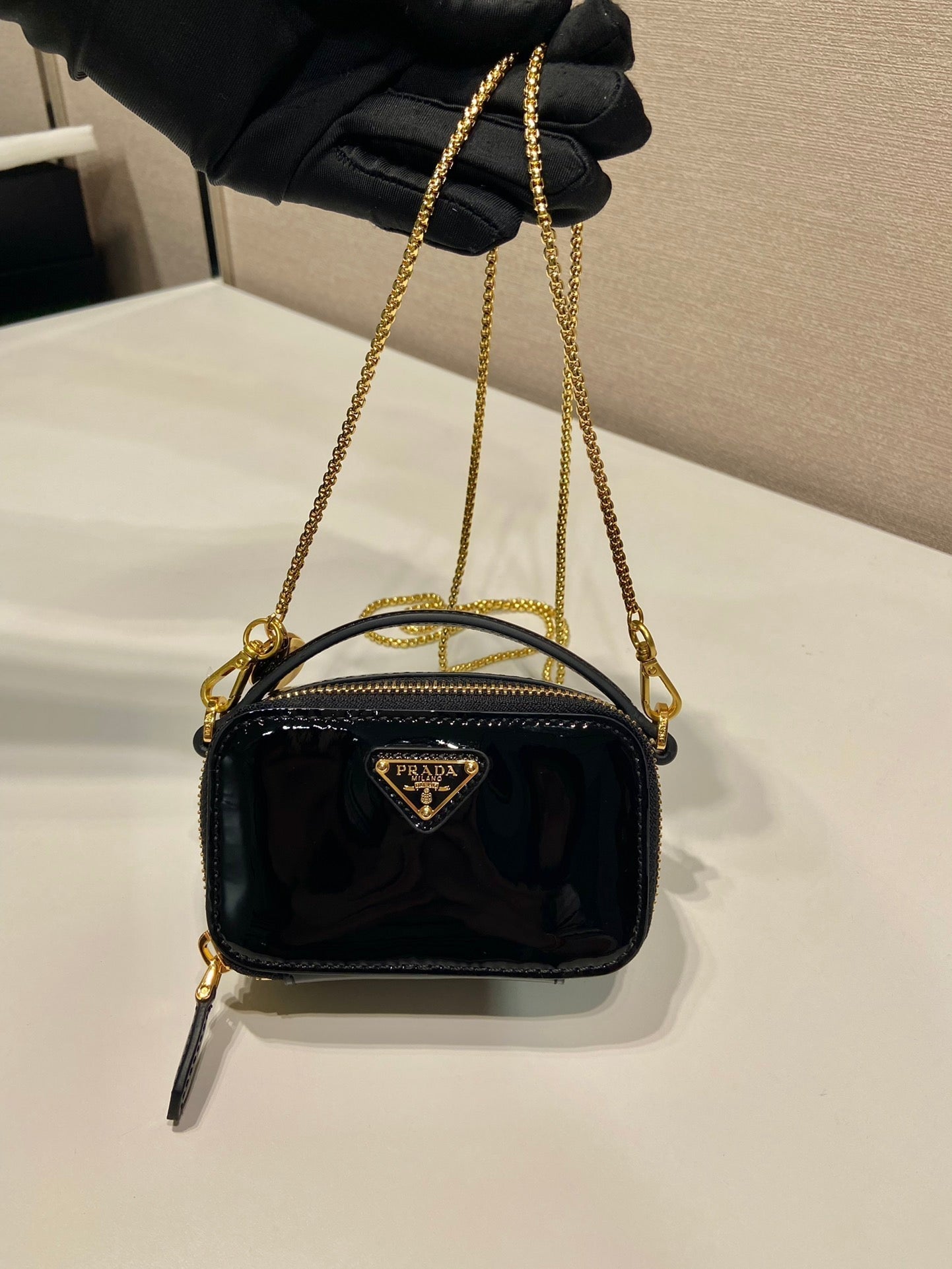 MINI BOLSO DE MANO 11 CON CORREA DORADA EN CHAROL NEGRO