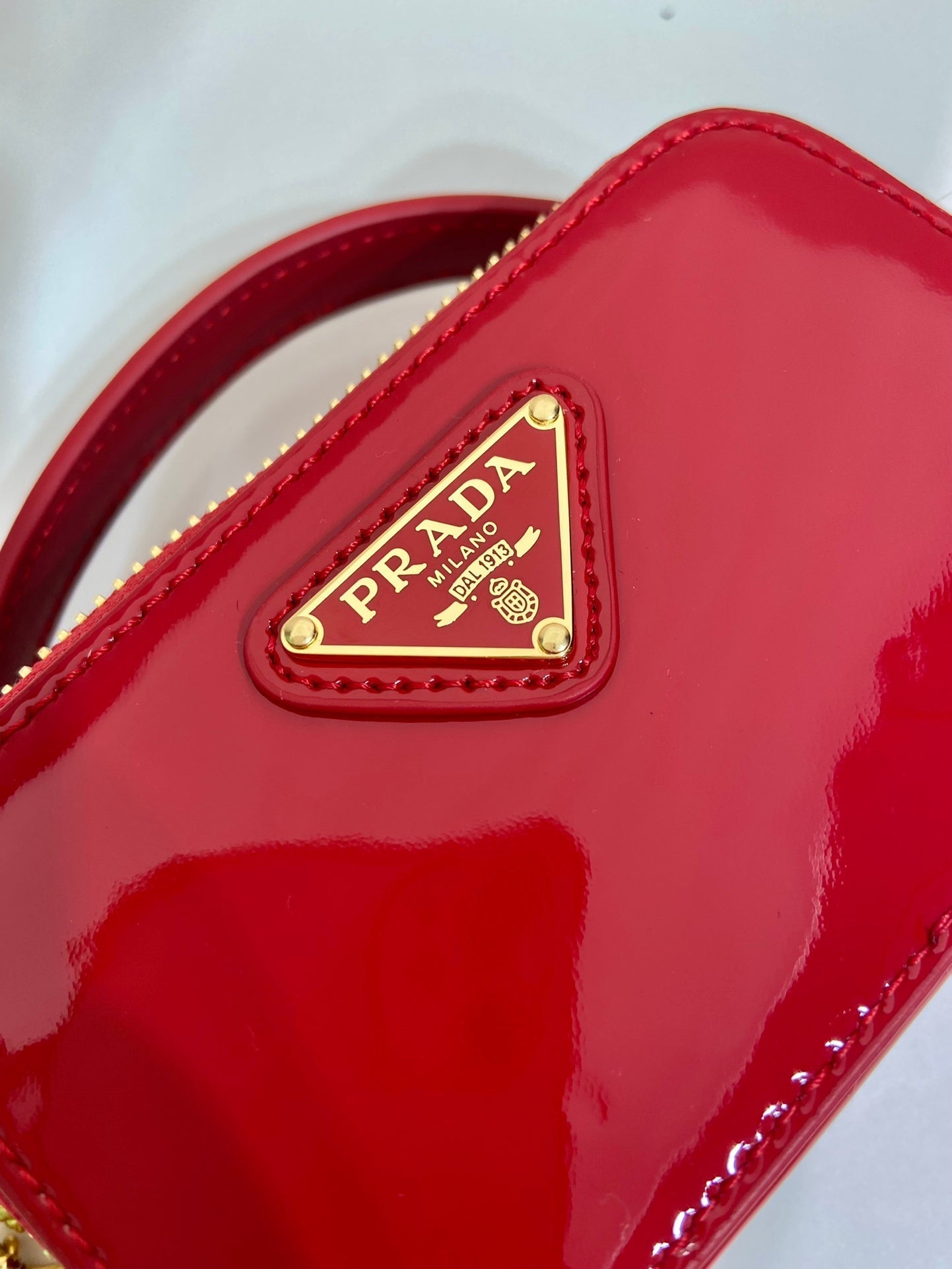 MINI BOLSO DE MANO 11 CON CORREA DORADA EN CHAROL ROJO