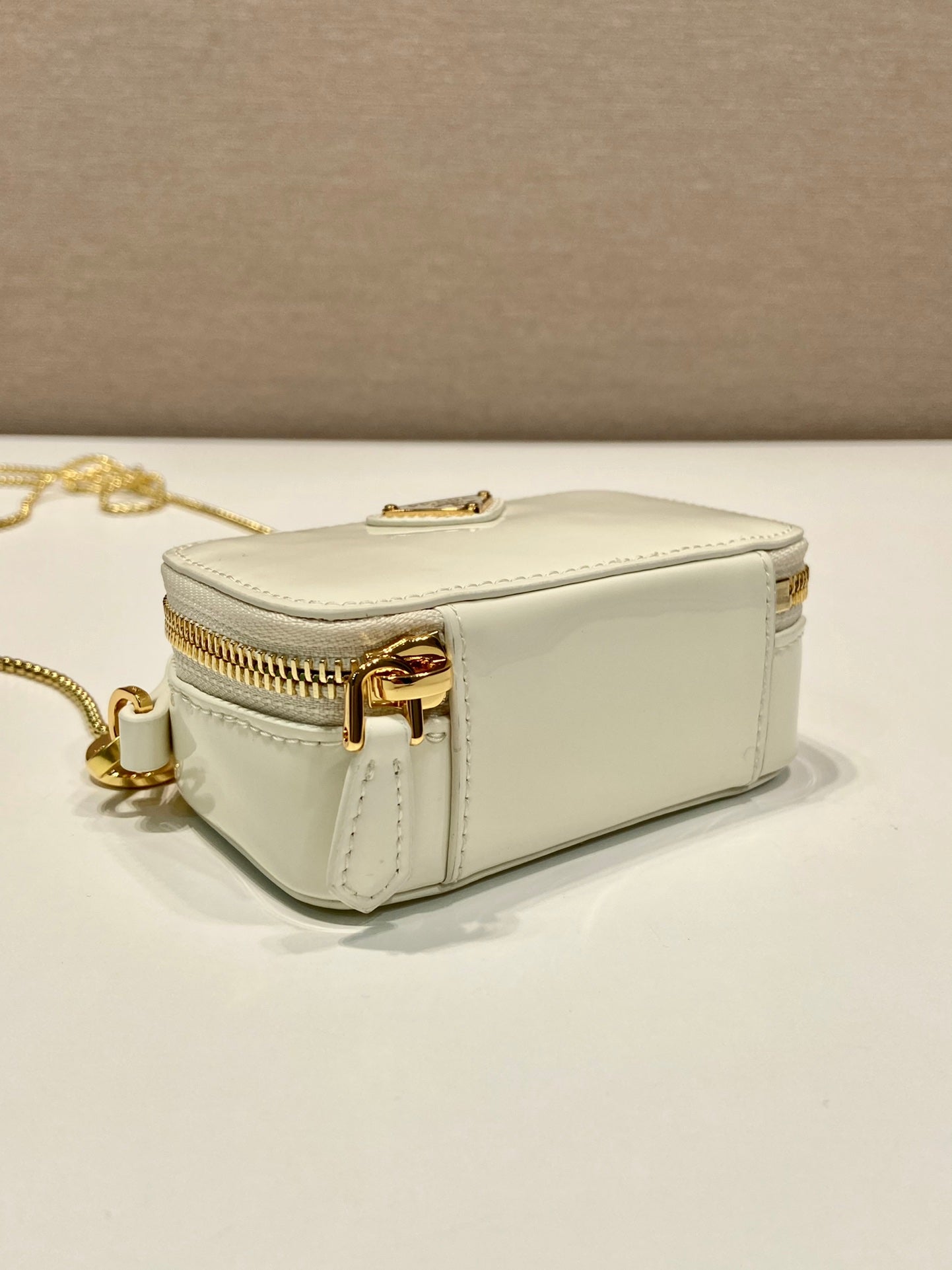 MINI BOLSO DE MANO 11 CON CORREA DORADA EN CHAROL BLANCO