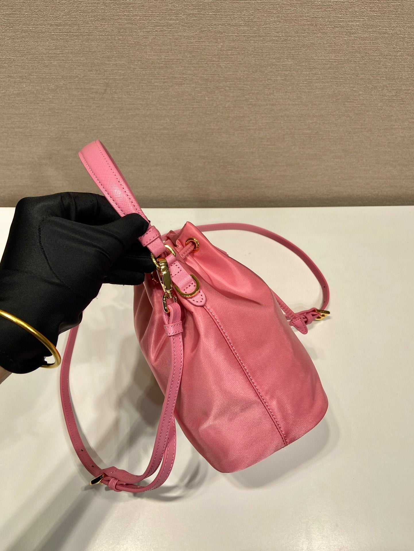 SAC SEAU 19 EN RE-NYLON ROSE BONBON ET POIGNÉE EN CUIR SAFFIANO