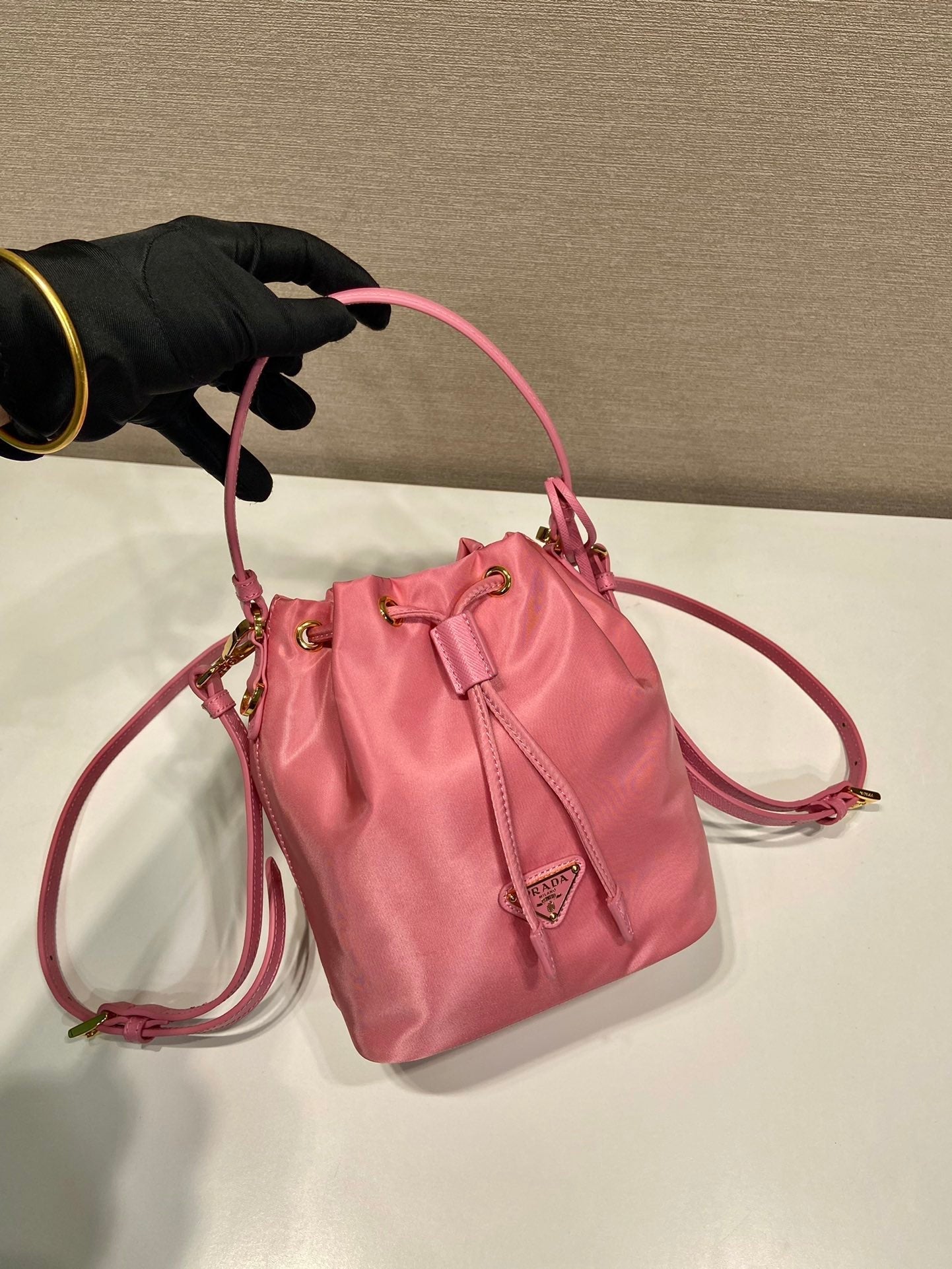 SAC SEAU 19 EN RE-NYLON ROSE BONBON ET POIGNÉE EN CUIR SAFFIANO