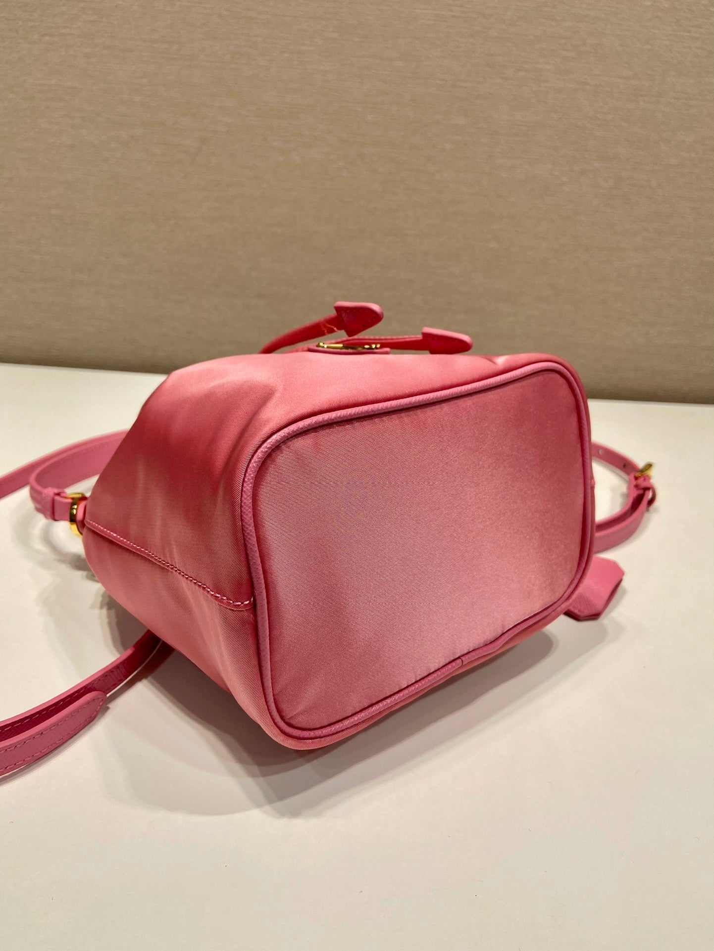 SAC SEAU 19 EN RE-NYLON ROSE BONBON ET POIGNÉE EN CUIR SAFFIANO