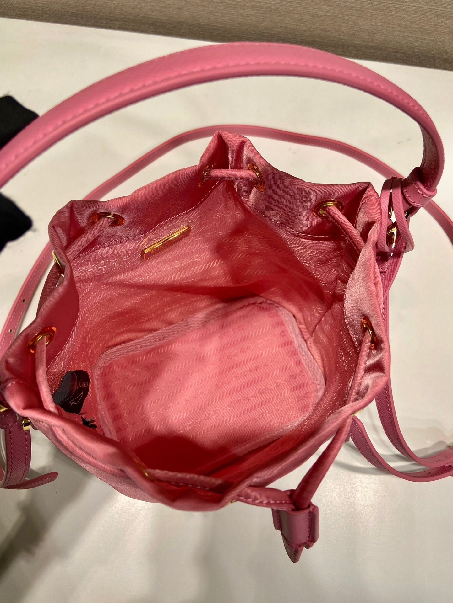 SAC SEAU 19 EN RE-NYLON ROSE BONBON ET POIGNÉE EN CUIR SAFFIANO