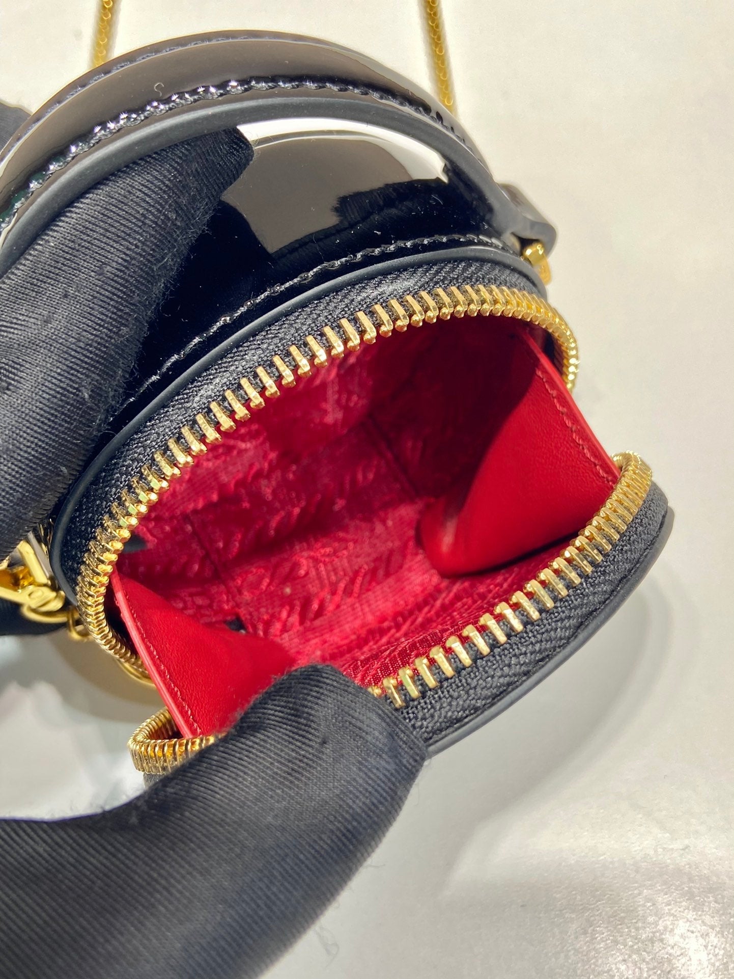 MINI BOLSO REDONDO 8 EN PIEL DE BECERRO NEGRA BRILLANTE CON HERRAJES DORADOS