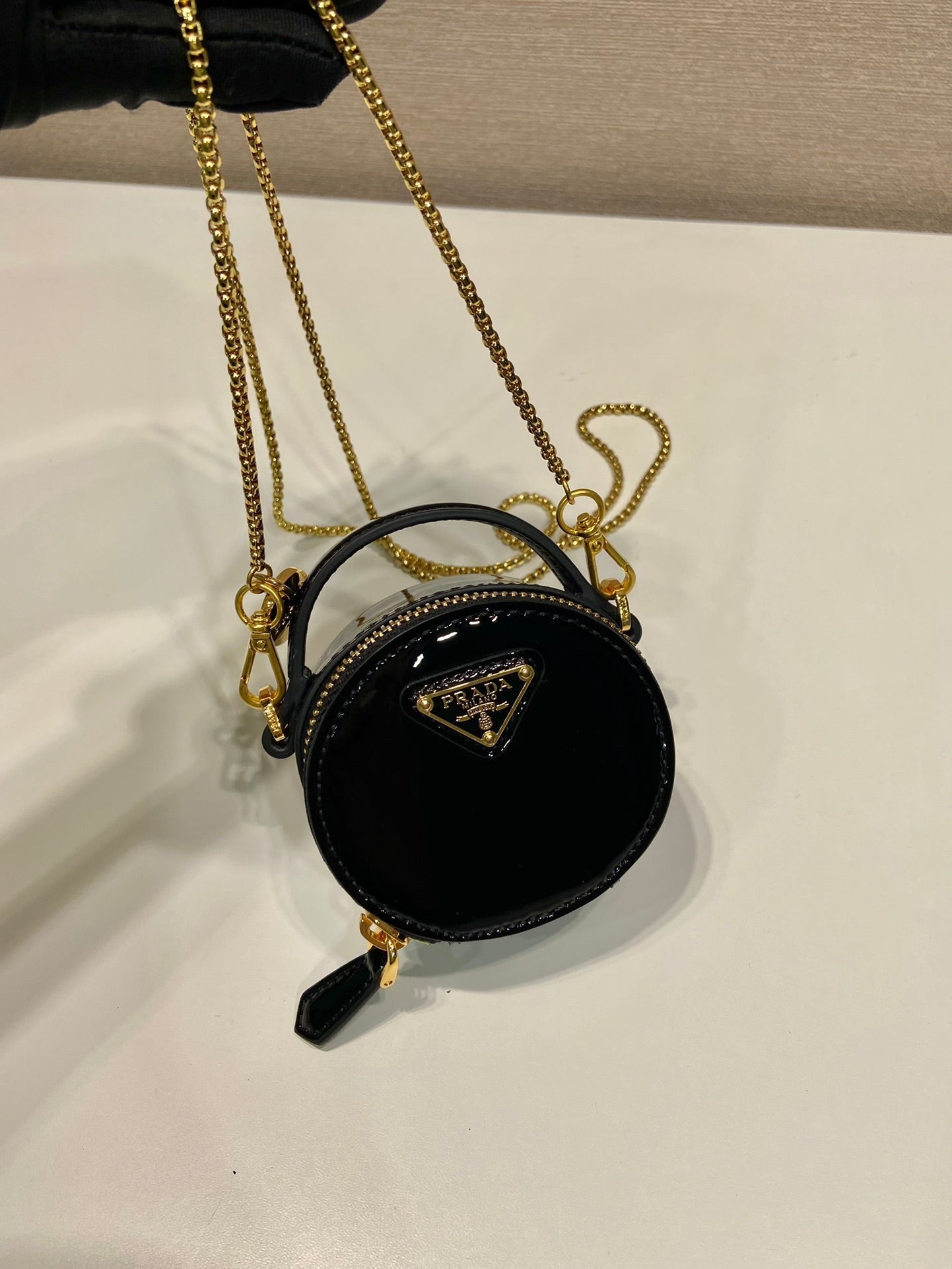MINI BOLSO REDONDO 8 EN PIEL DE BECERRO NEGRA BRILLANTE CON HERRAJES DORADOS