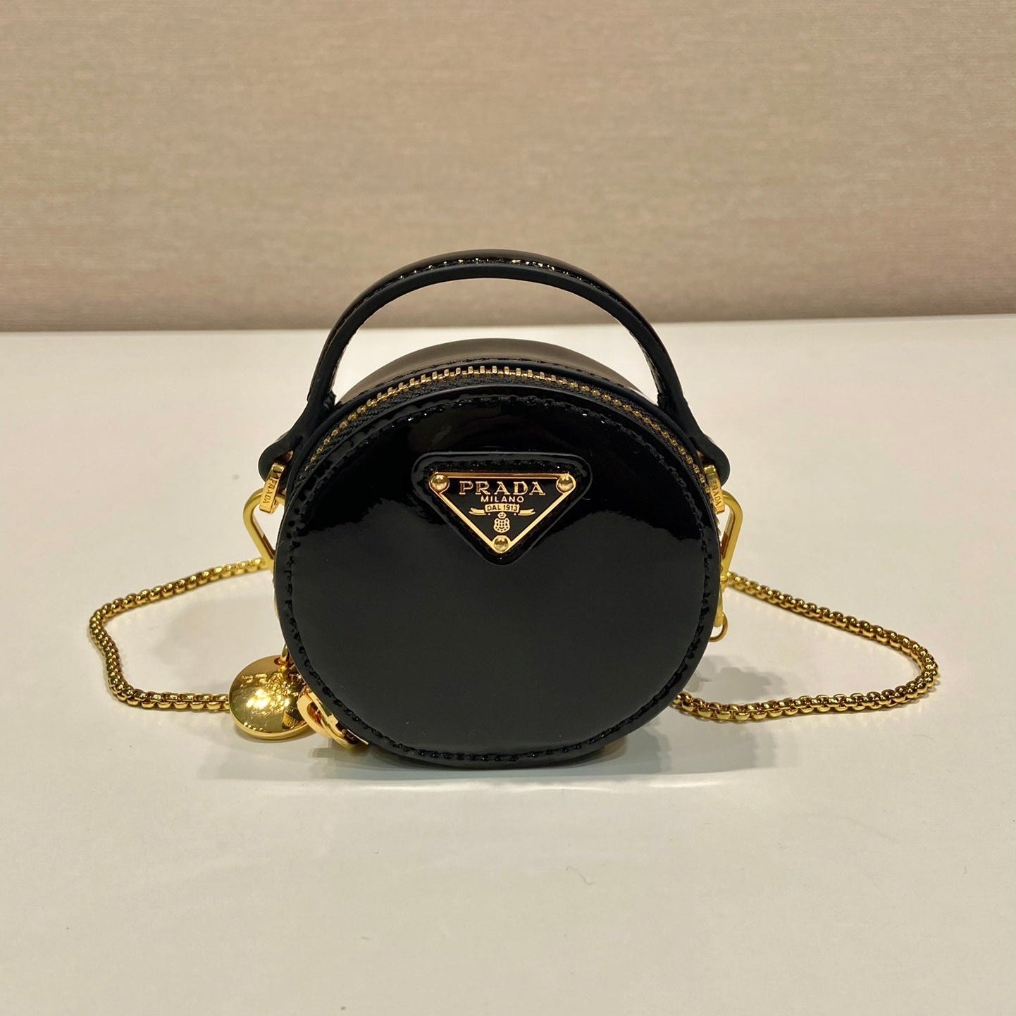 MINI BOLSO REDONDO 8 EN PIEL DE BECERRO NEGRA BRILLANTE CON HERRAJES DORADOS