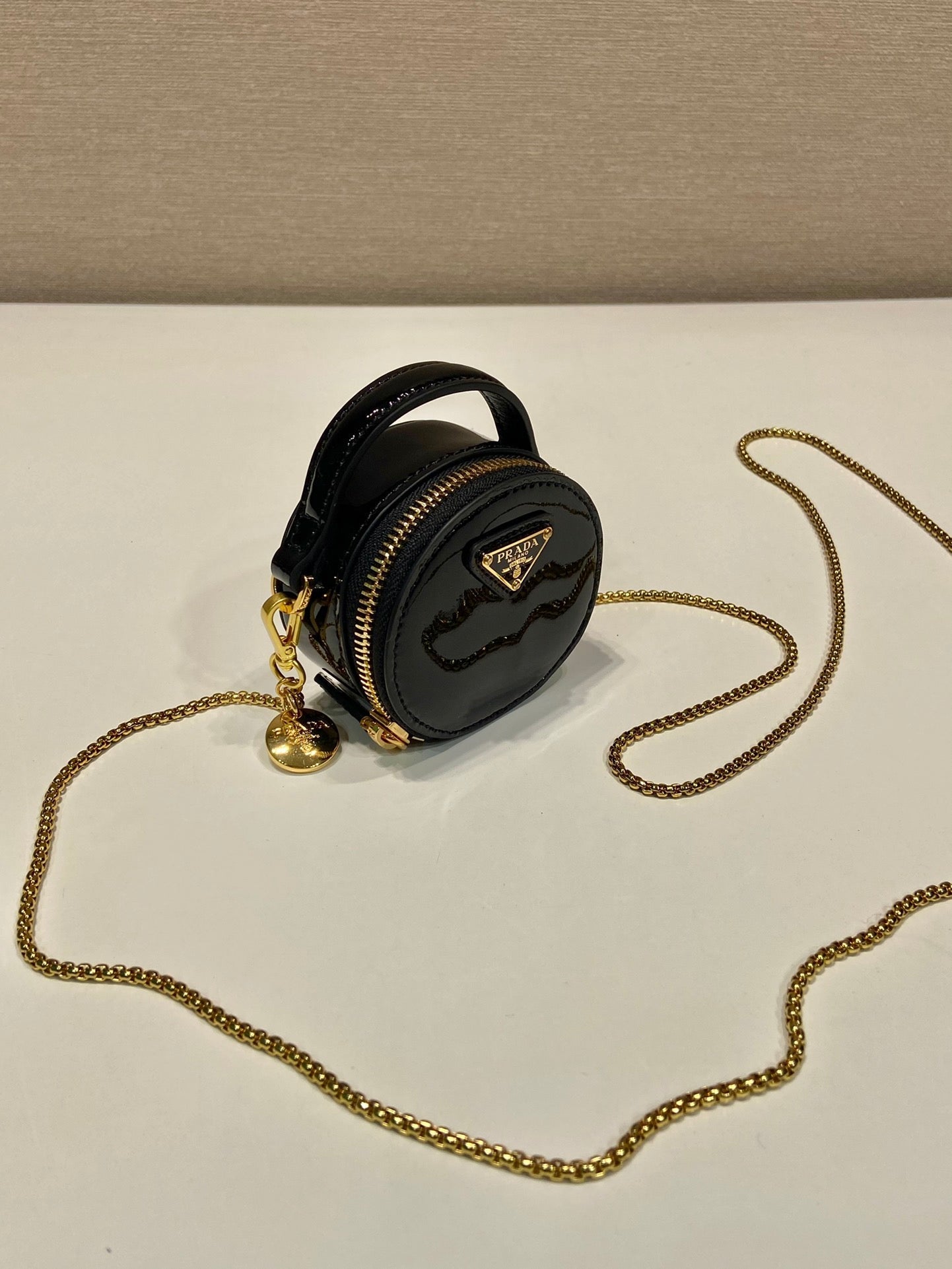 MINI BOLSO REDONDO 8 EN PIEL DE BECERRO NEGRA BRILLANTE CON HERRAJES DORADOS