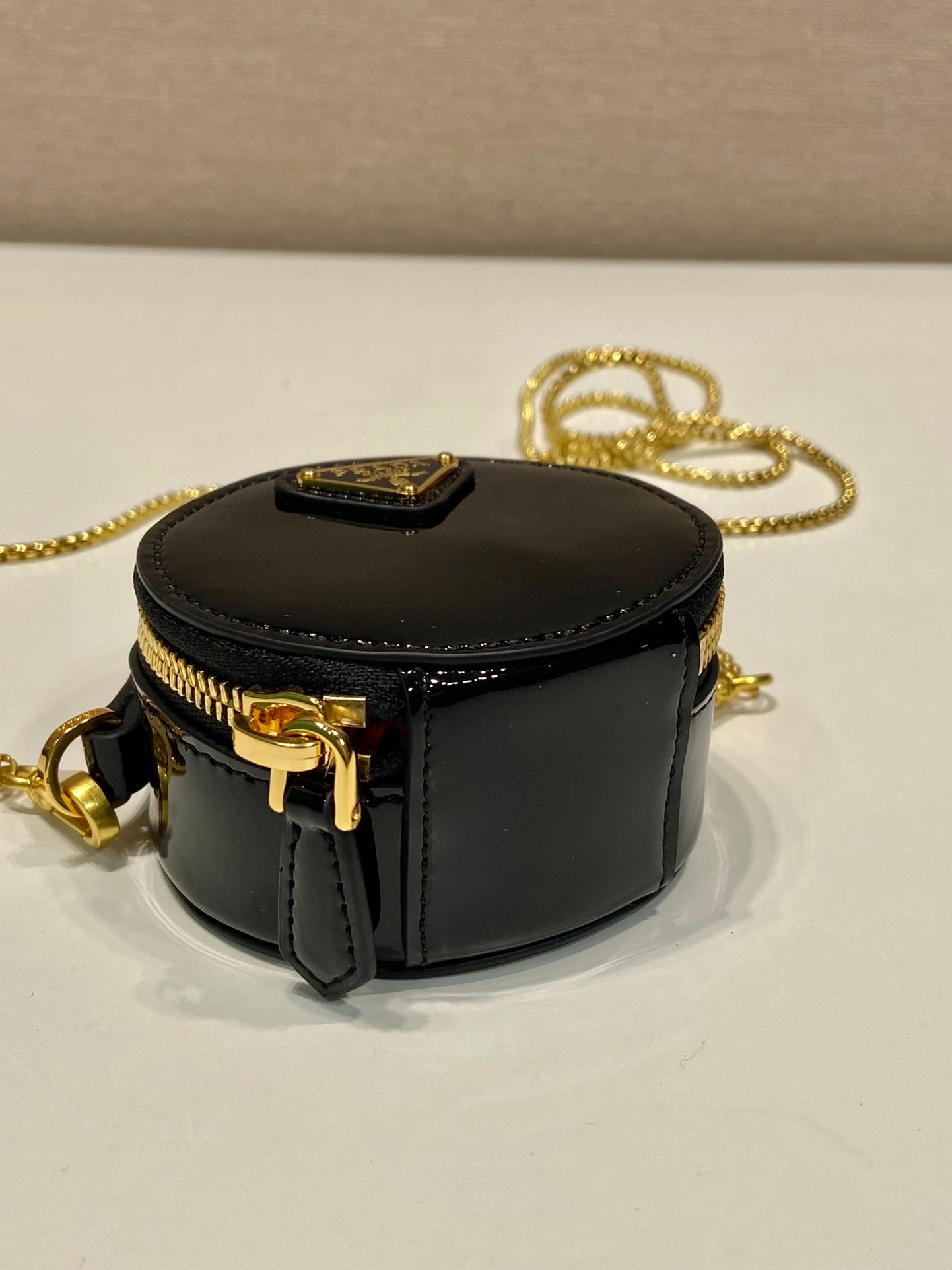 MINI BOLSO REDONDO 8 EN PIEL DE BECERRO NEGRA BRILLANTE CON HERRAJES DORADOS