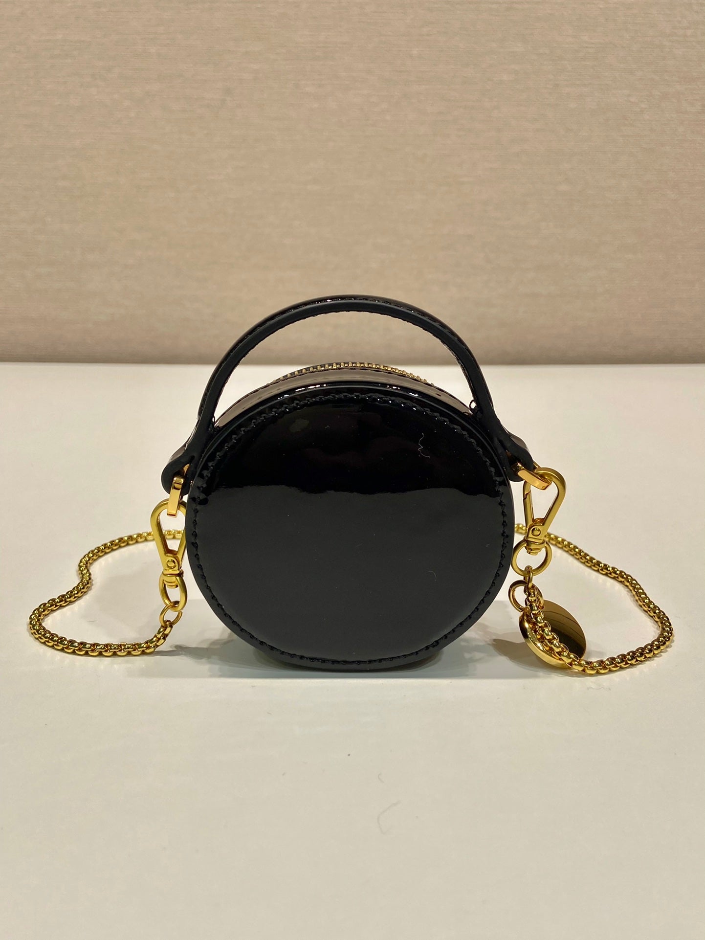 MINI BOLSO REDONDO 8 EN PIEL DE BECERRO NEGRA BRILLANTE CON HERRAJES DORADOS