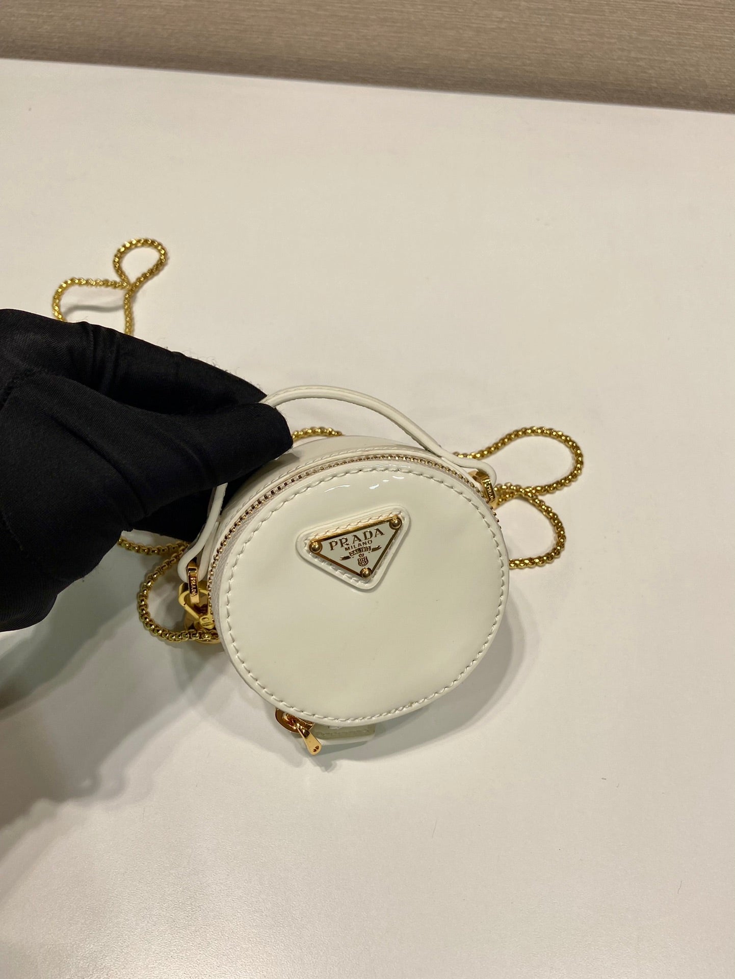 MINI BOLSO REDONDO 8 EN PIEL DE BECERRO BLANCA BRILLANTE CON HERRAJES DORADOS