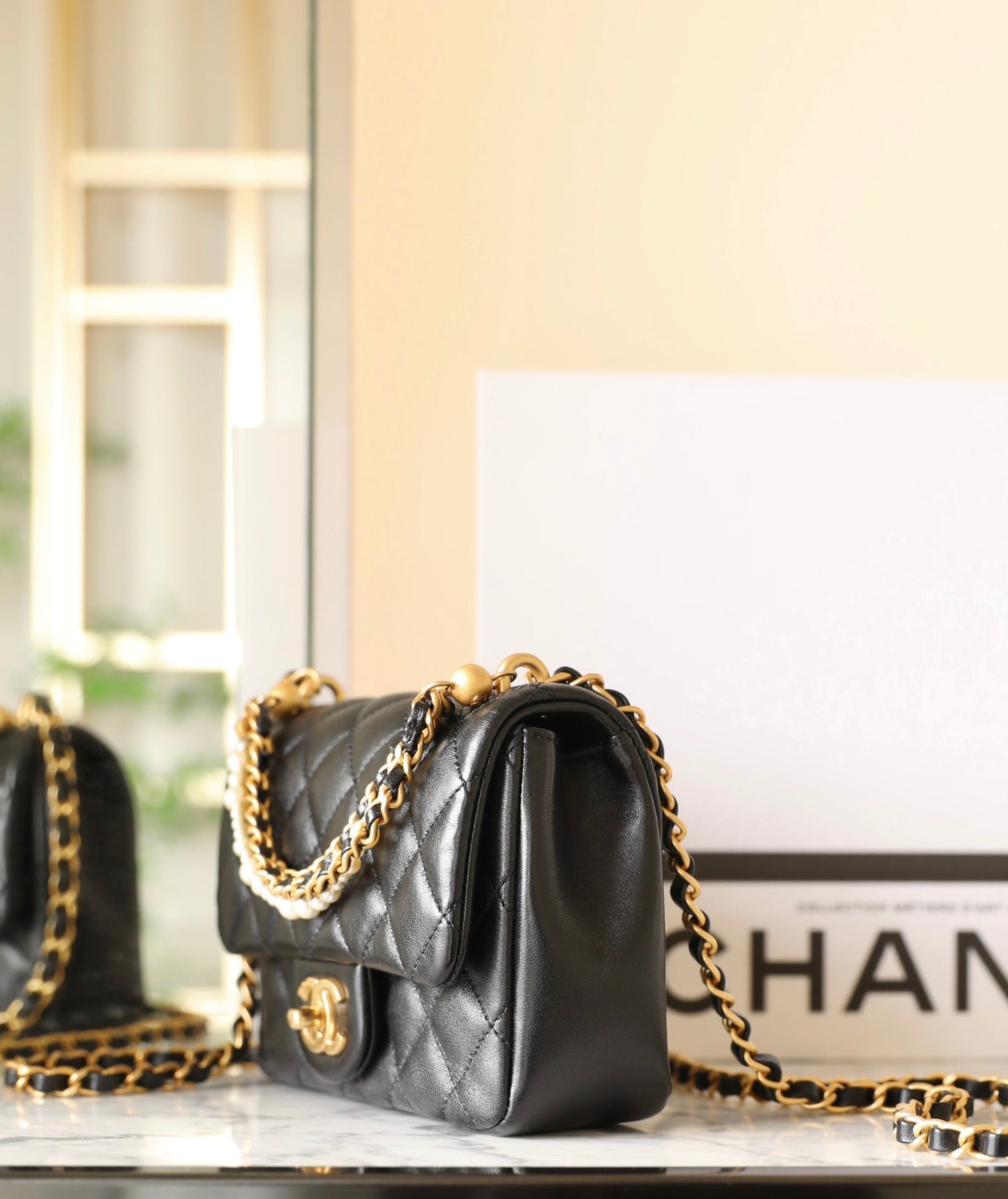 Bolso mini con solapa CC 24P de 17 cm con cadena de perlas y piel de cordero negra