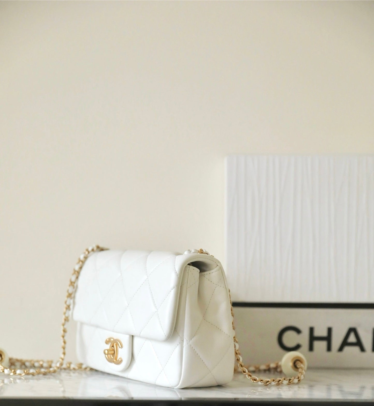 Bolso mini con solapa CC 24S de 20 cm, piel de cordero blanca con bola de perla