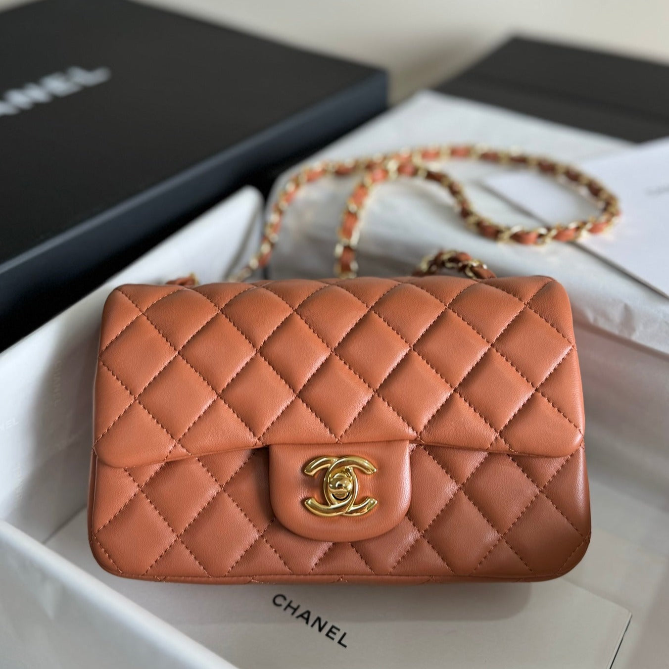 Bolso mini con solapa de 20 cm de piel de cordero marrón y herrajes dorados