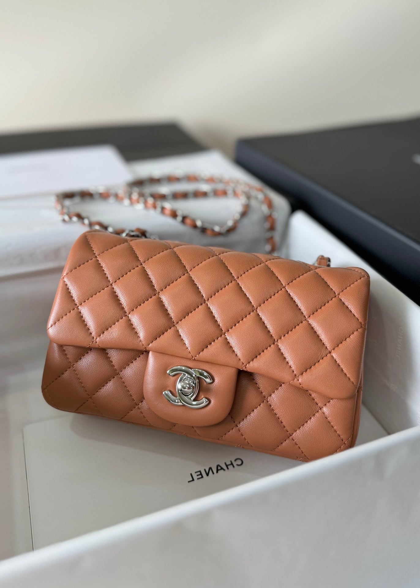 Bolso mini con solapa de 20 cm de piel de cordero marrón y herrajes plateados