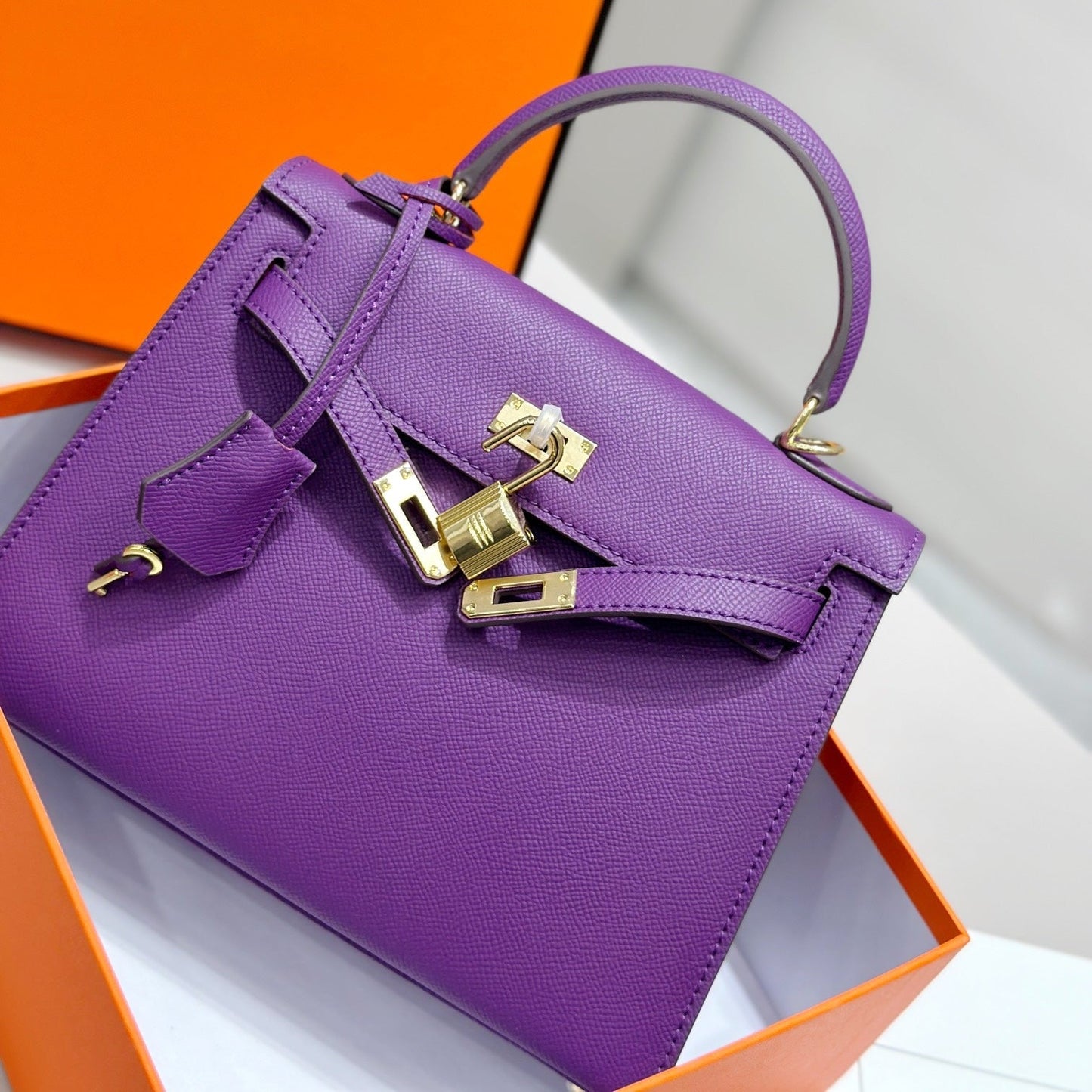 HM Kelly 25 cm, piel Epsom morada, herrajes dorados