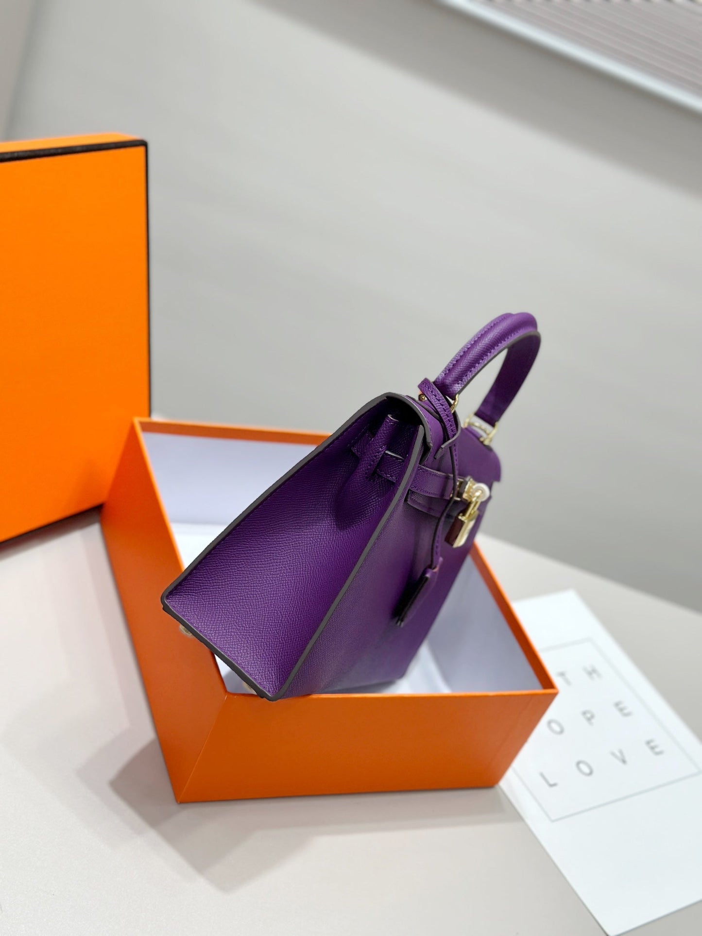 HM Kelly 25 cm, piel Epsom morada, herrajes dorados