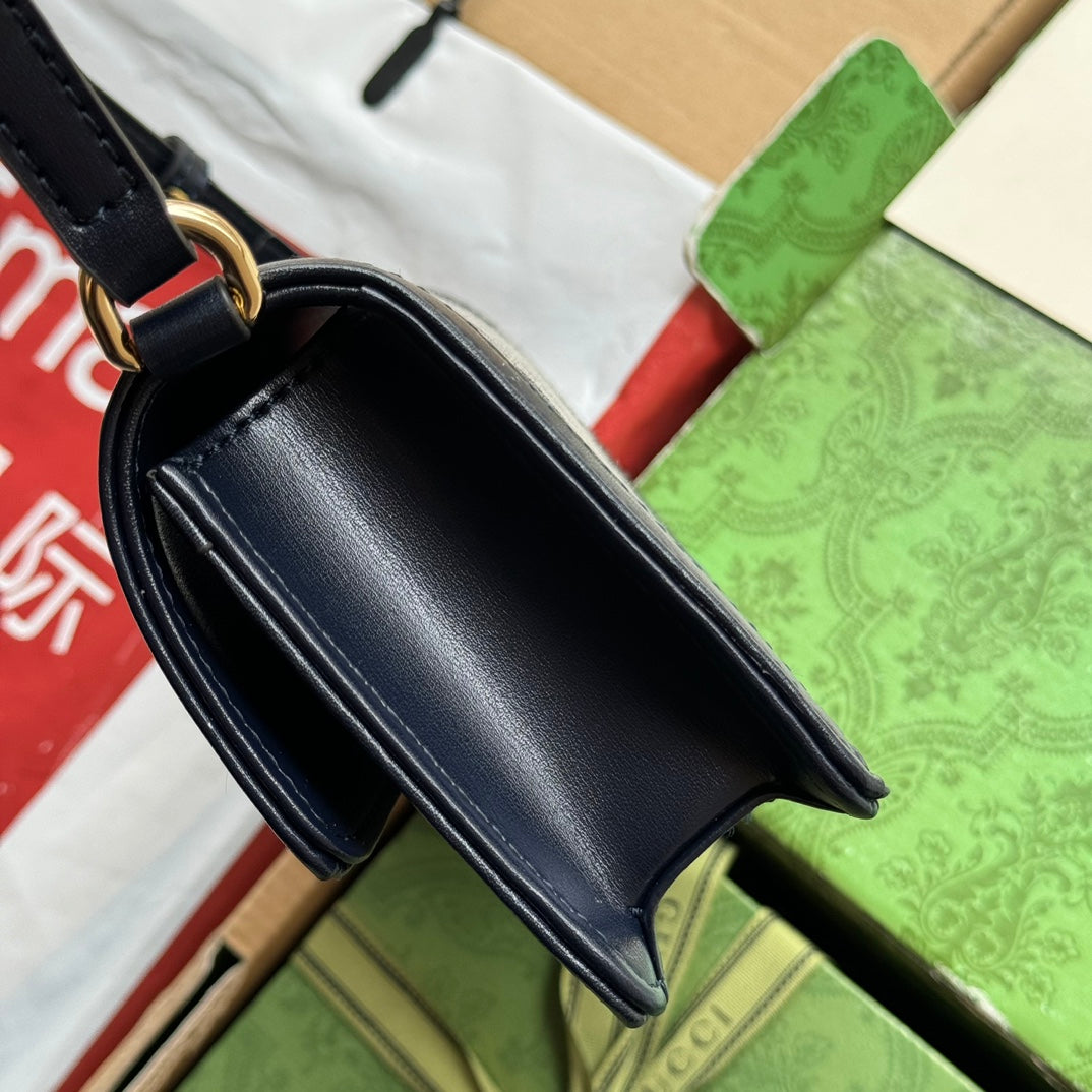 Mini sac bandoulière Luce 20 en toile gris clair et garniture en cuir de veau noir, matériel doré