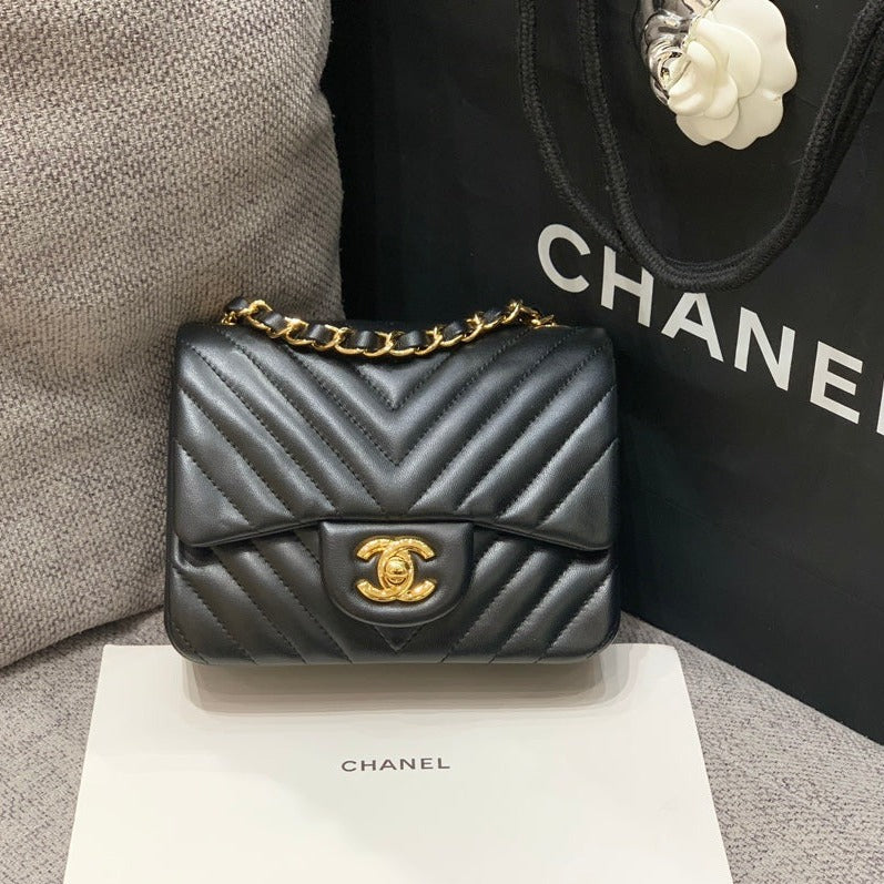 MINI BOLSO CUADRADO CON SOLAPA DE 17 CM EN PIEL DE CORDERO NEGRA CON CHEURÓN Y HERRAJES DORADOS
