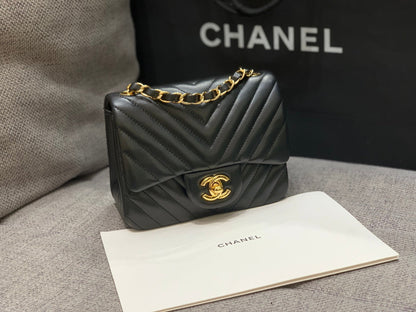 MINI BOLSO CUADRADO CON SOLAPA DE 17 CM EN PIEL DE CORDERO NEGRA CON CHEURÓN Y HERRAJES DORADOS