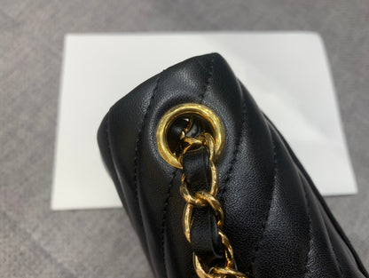 MINI BOLSO CUADRADO CON SOLAPA DE 17 CM EN PIEL DE CORDERO NEGRA CON CHEURÓN Y HERRAJES DORADOS