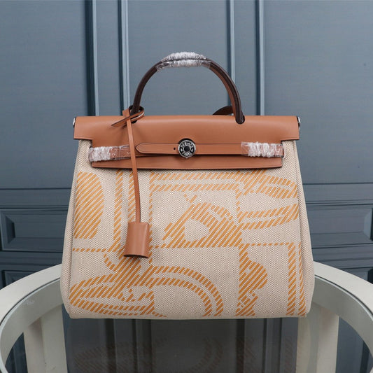 HM HERBAG ZIP 31 LONA CON MONOGRAMA DE SIDRA Y CREMA