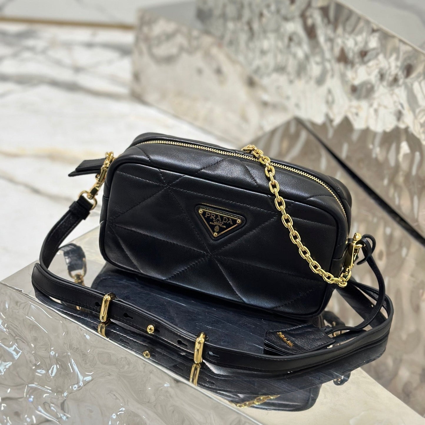 BOLSO PARA CÁMARA 22 EN PIEL DE CORDERO ACOLCHADA CON ESTAMPADO DE TRIÁNGULOS NEGROS Y HERRAJES DORADOS