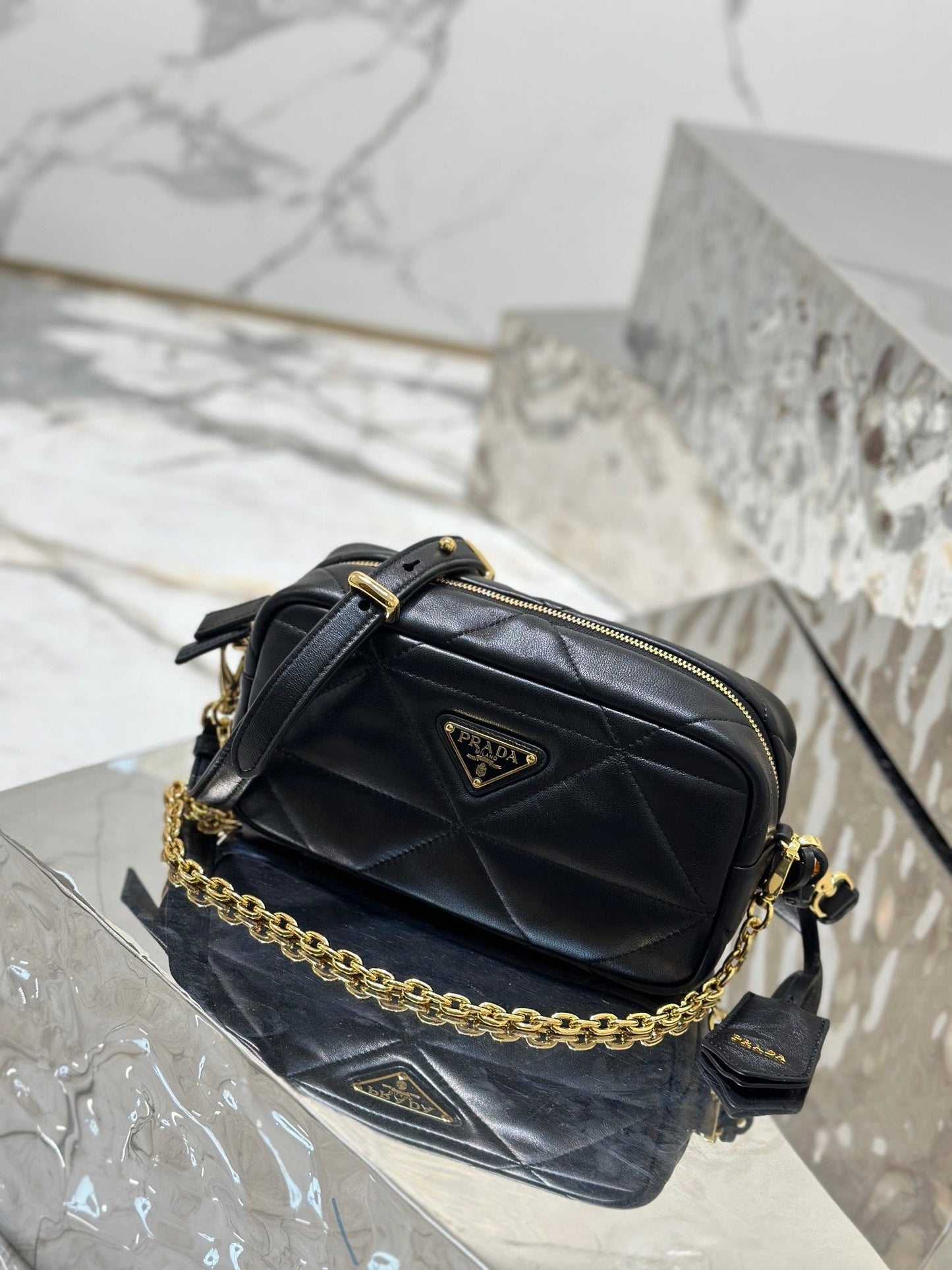 BOLSO PARA CÁMARA 22 EN PIEL DE CORDERO ACOLCHADA CON ESTAMPADO DE TRIÁNGULOS NEGROS Y HERRAJES DORADOS