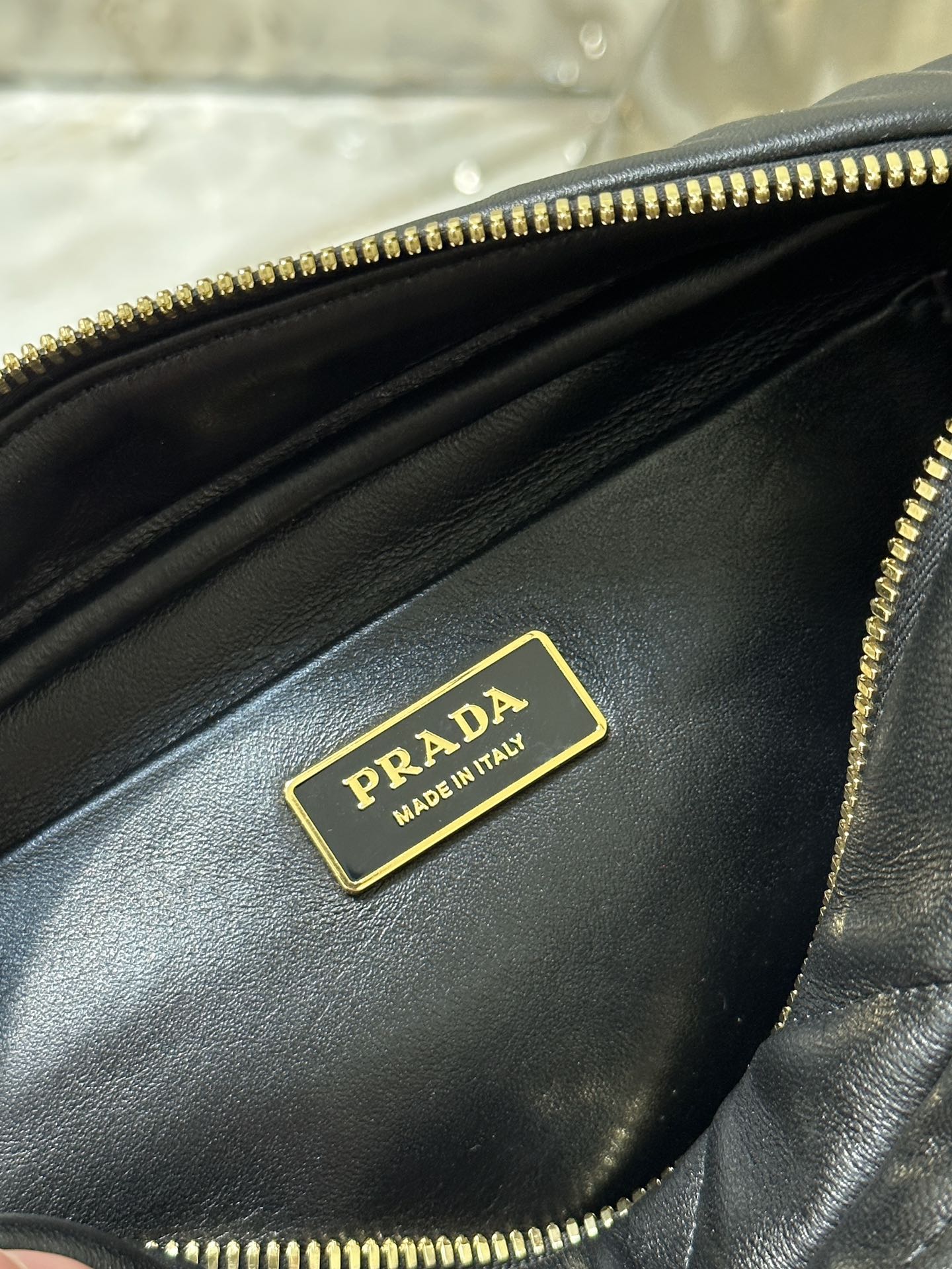 BOLSO PARA CÁMARA 22 EN PIEL DE CORDERO ACOLCHADA CON ESTAMPADO DE TRIÁNGULOS NEGROS Y HERRAJES DORADOS
