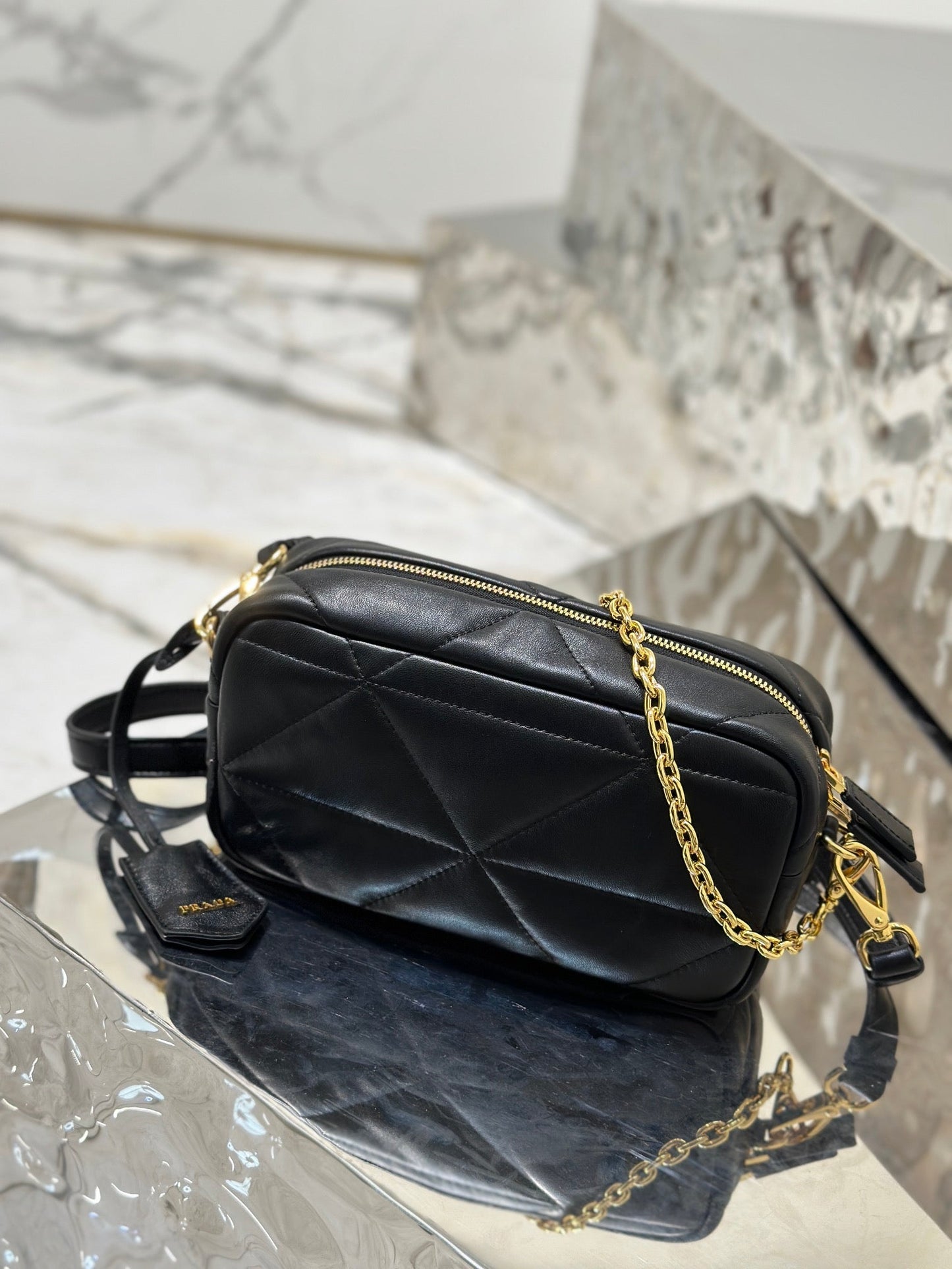 BOLSO PARA CÁMARA 22 EN PIEL DE CORDERO ACOLCHADA CON ESTAMPADO DE TRIÁNGULOS NEGROS Y HERRAJES DORADOS