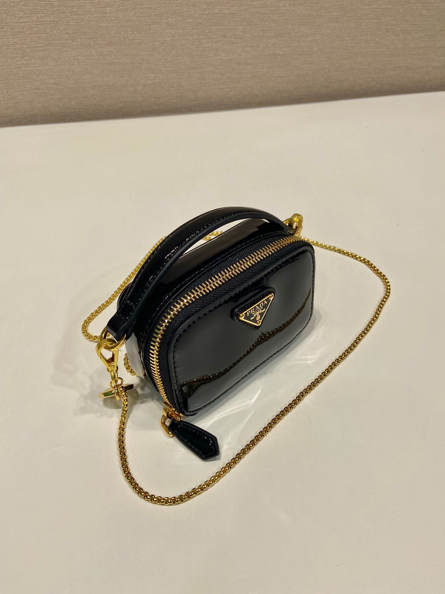 MINI BOLSO DE MANO 11 CON CORREA DORADA EN CHAROL NEGRO