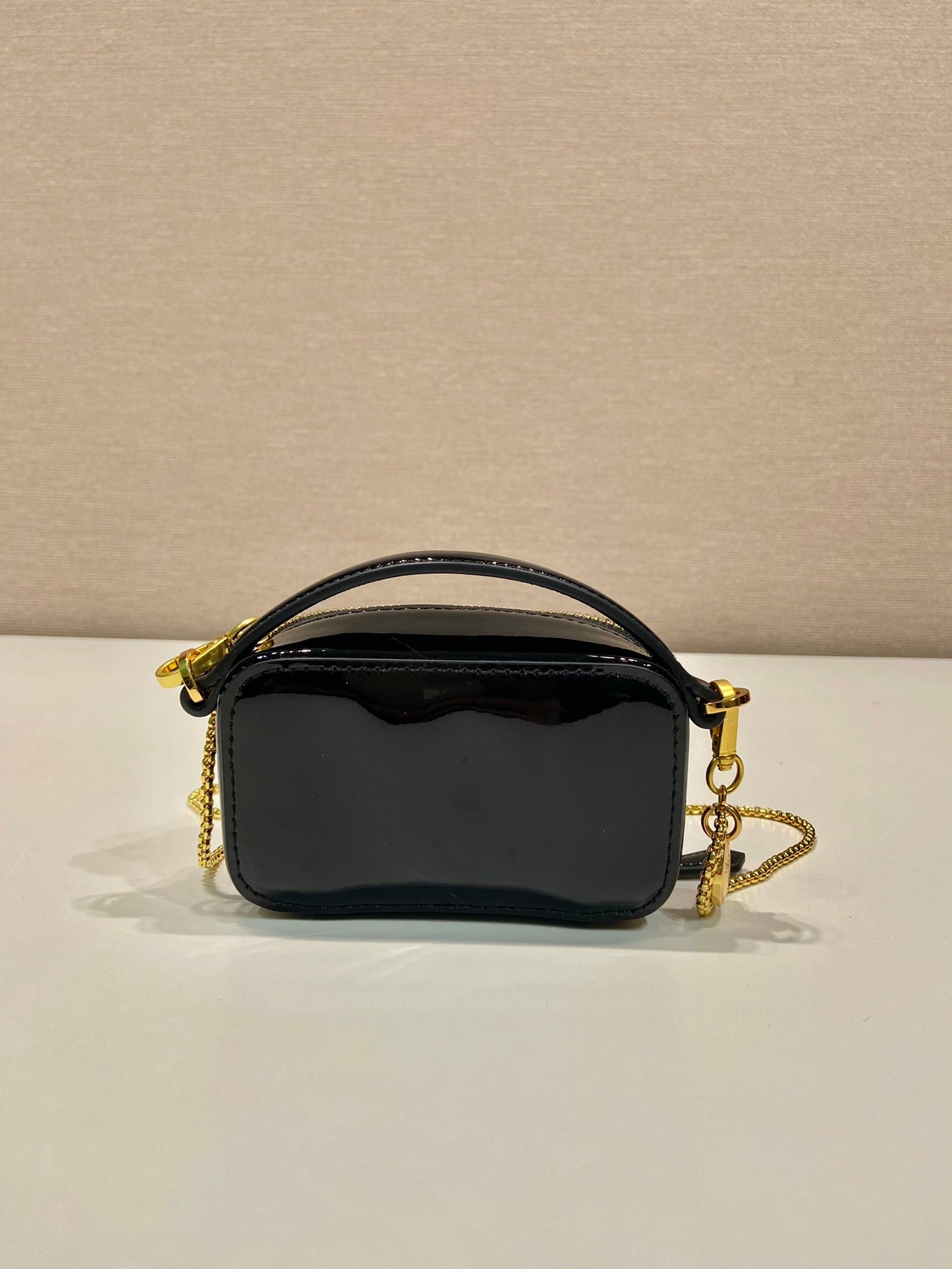 MINI BOLSO DE MANO 11 CON CORREA DORADA EN CHAROL NEGRO