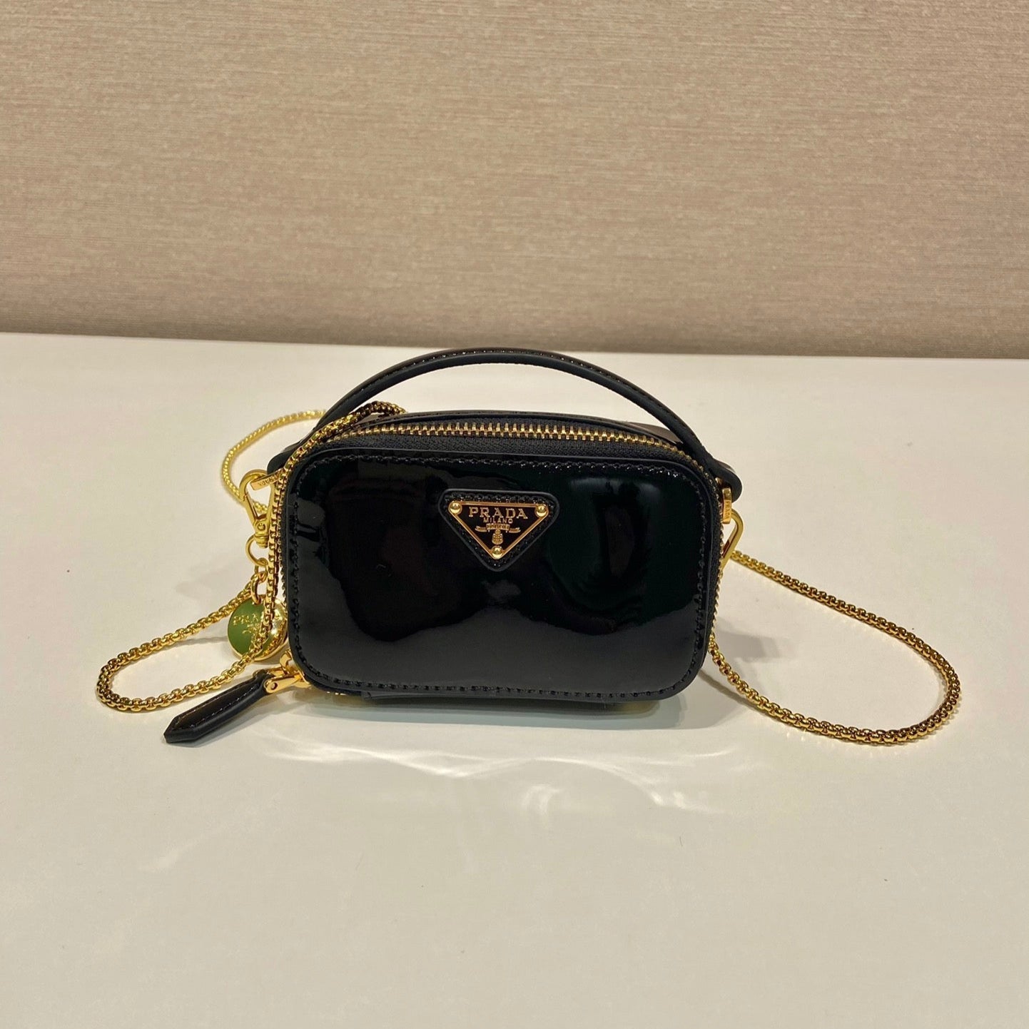 MINI BOLSO DE MANO 11 CON CORREA DORADA EN CHAROL NEGRO