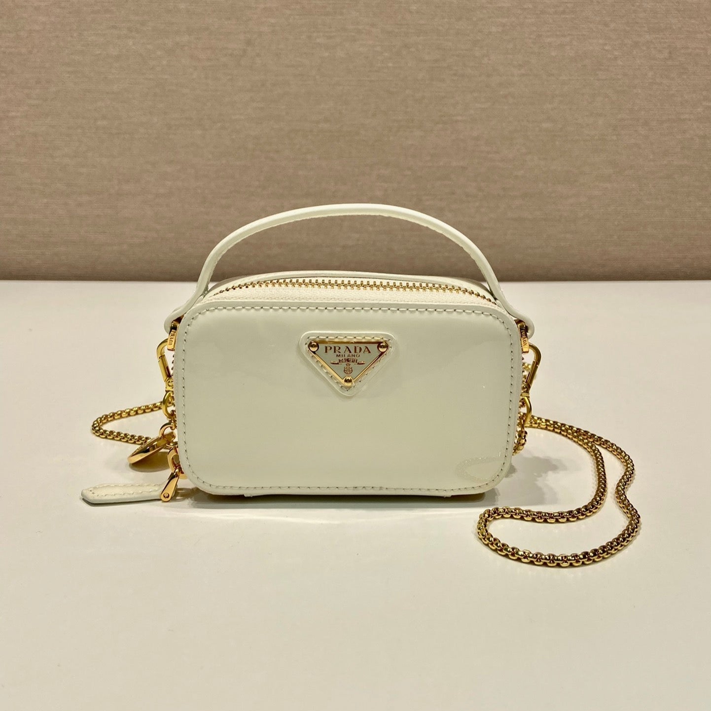 MINI BOLSO DE MANO 11 CON CORREA DORADA EN CHAROL BLANCO