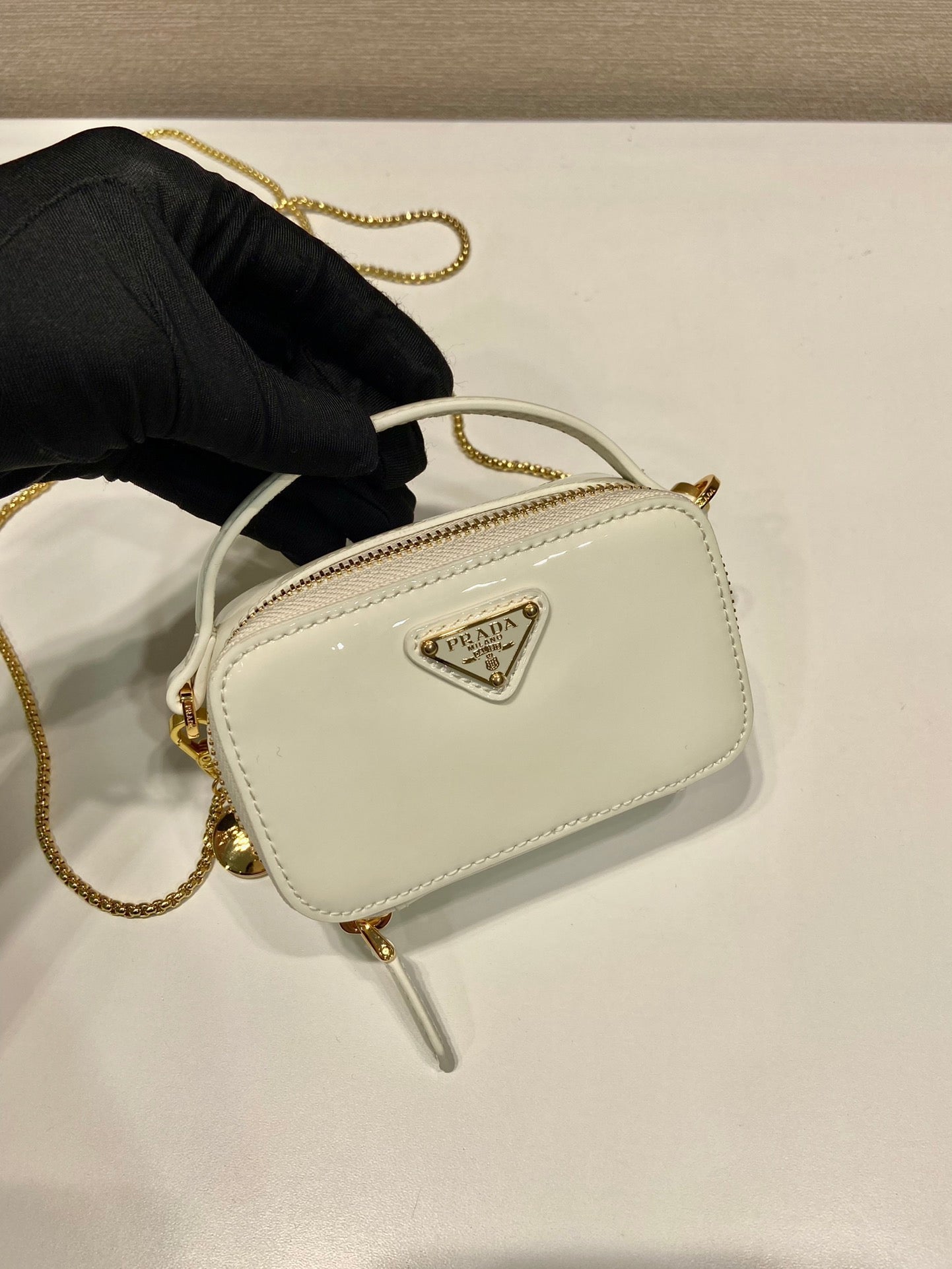 MINI BOLSO DE MANO 11 CON CORREA DORADA EN CHAROL BLANCO