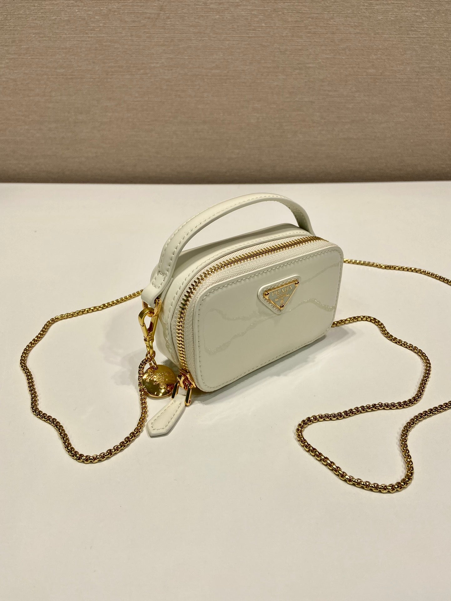 MINI BOLSO DE MANO 11 CON CORREA DORADA EN CHAROL BLANCO