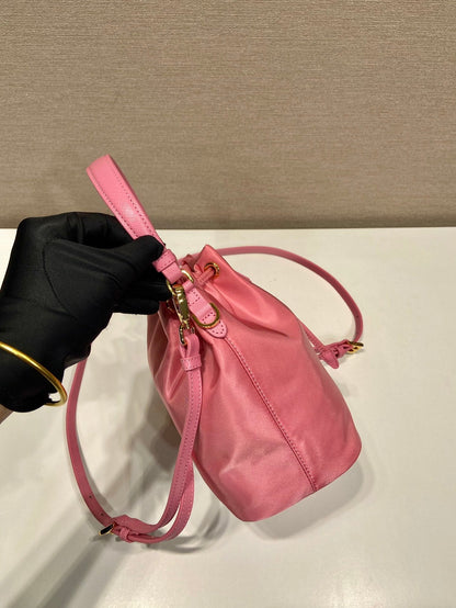 SAC SEAU 19 EN RE-NYLON ROSE BONBON ET POIGNÉE EN CUIR SAFFIANO