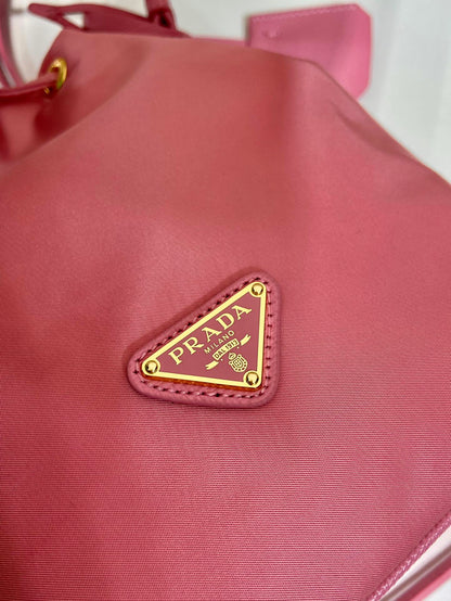 SAC SEAU 19 EN RE-NYLON ROSE BONBON ET POIGNÉE EN CUIR SAFFIANO