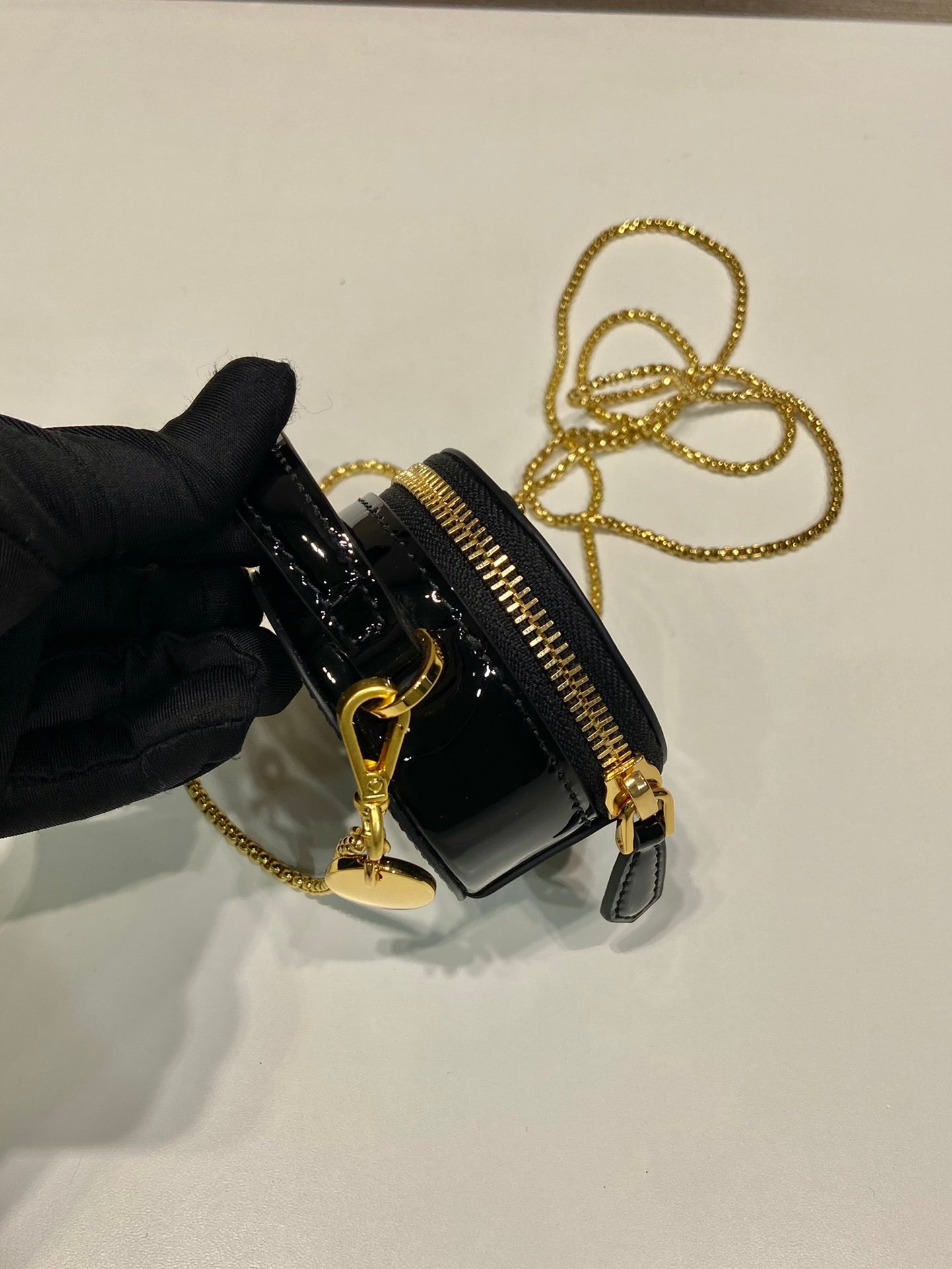 MINI BOLSO REDONDO 8 EN PIEL DE BECERRO NEGRA BRILLANTE CON HERRAJES DORADOS