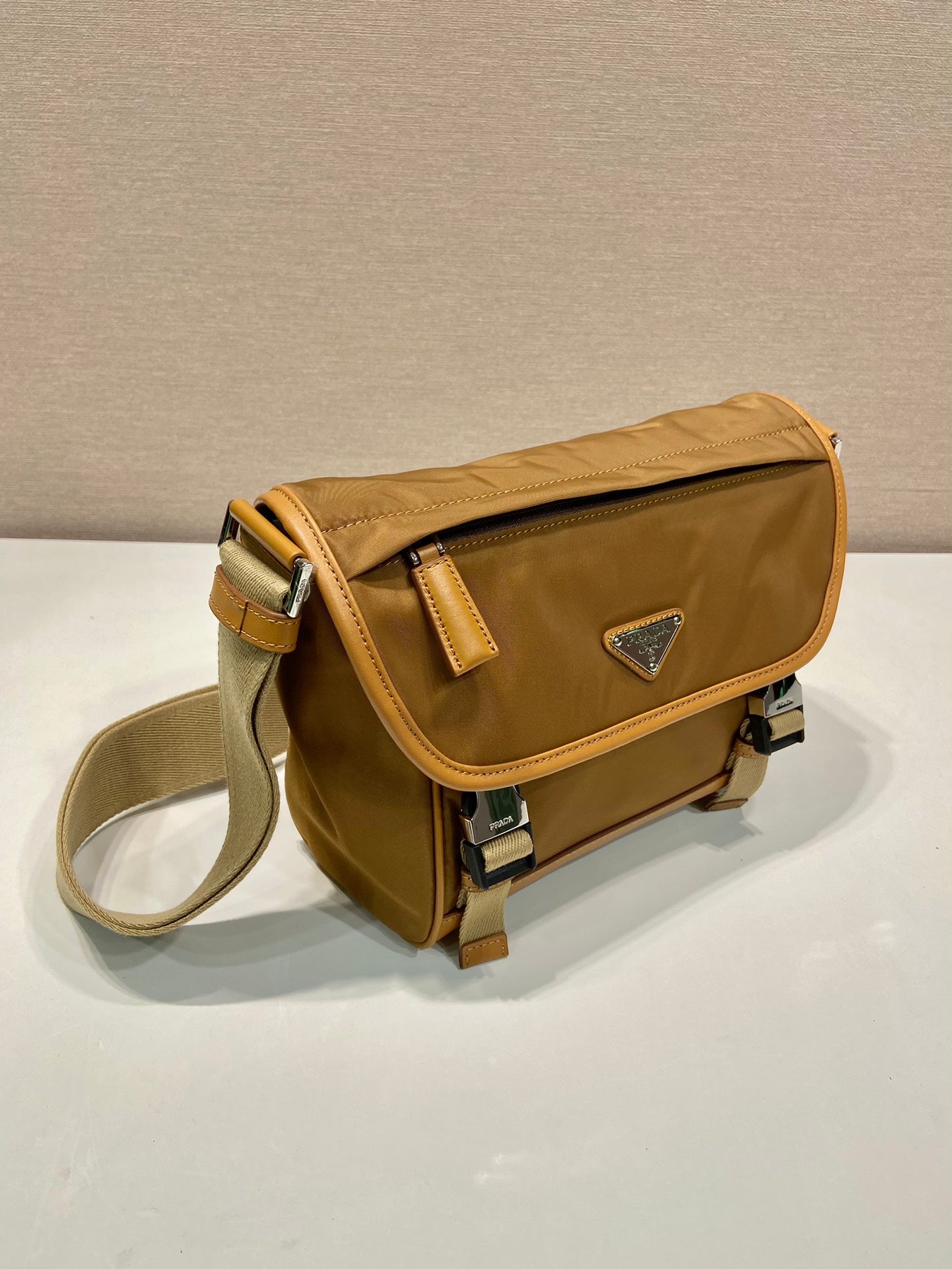 BOLSO PEQUEÑO CON SOLAPA 20 EN RE-NYLON MARRÓN SIDRA Y RIBETE DE PIEL DE BECERRO
