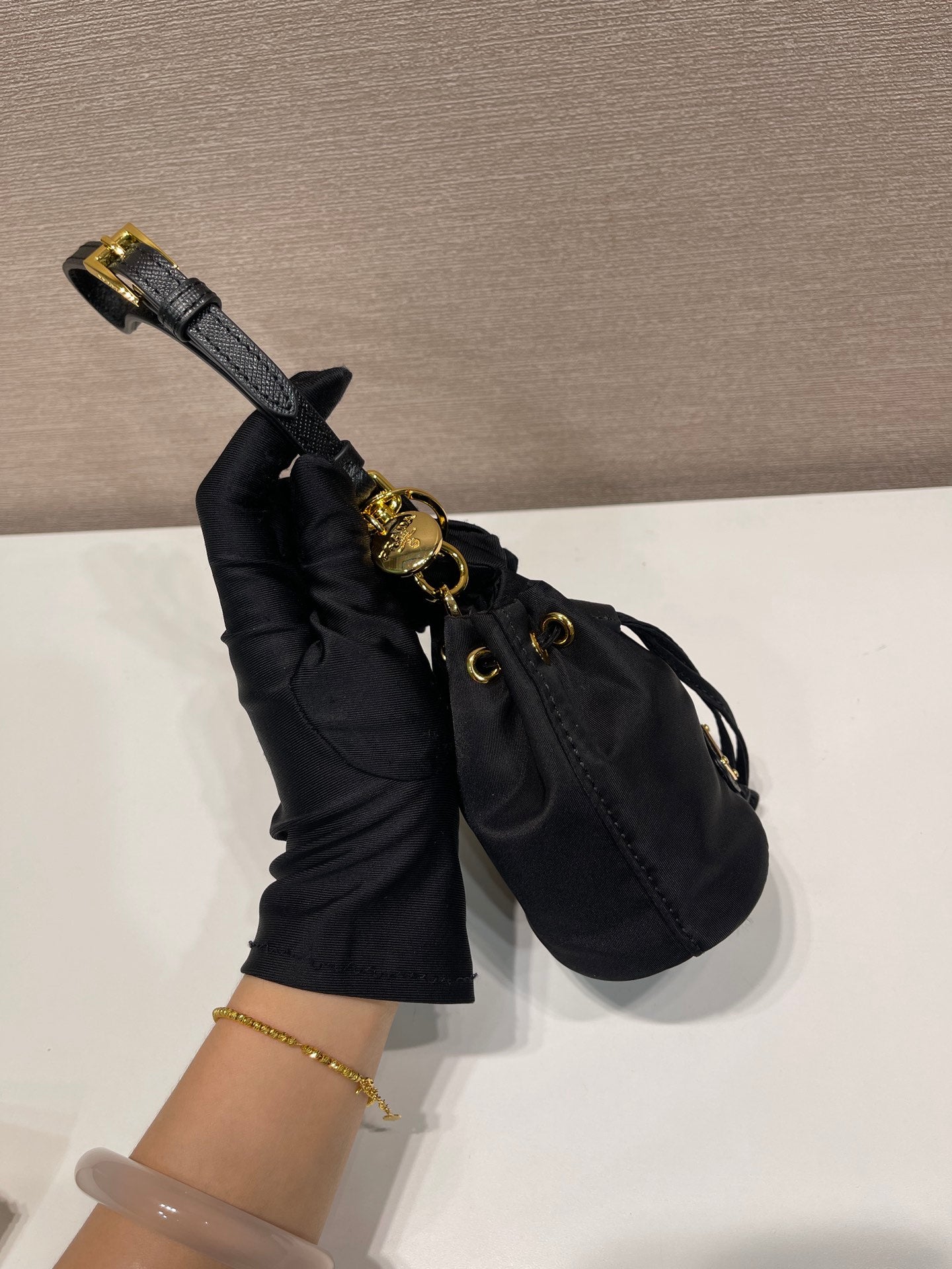 MINI BOLSO BUCKET 10 EN RE-NYLON NEGRO Y CORREA DE PIEL SAFFIANO