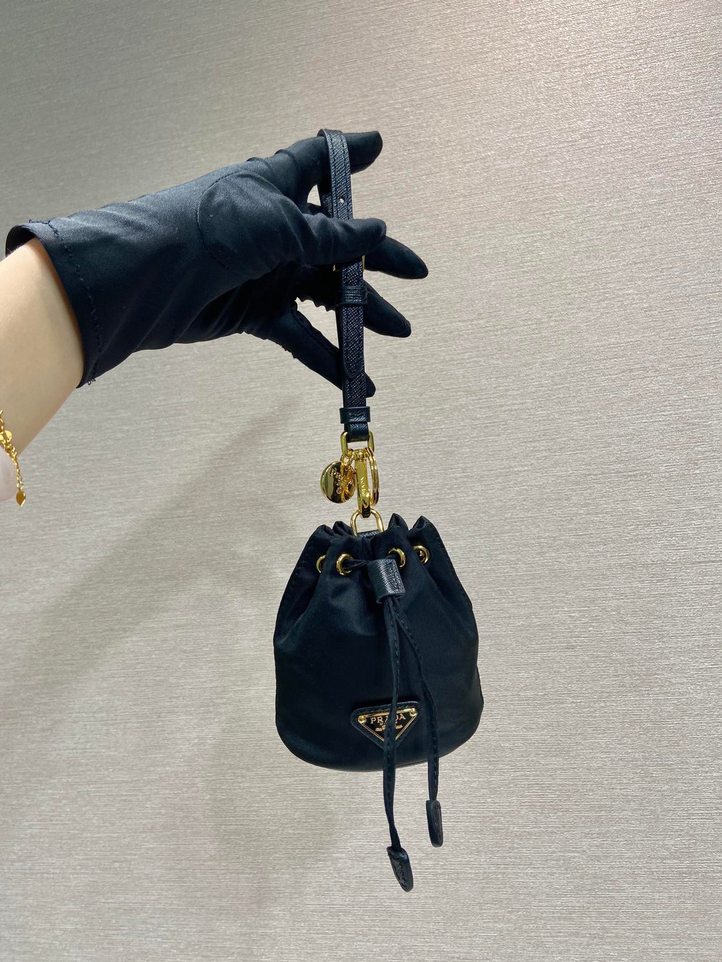 MINI BOLSO BUCKET 10 EN RE-NYLON NEGRO Y CORREA DE PIEL SAFFIANO