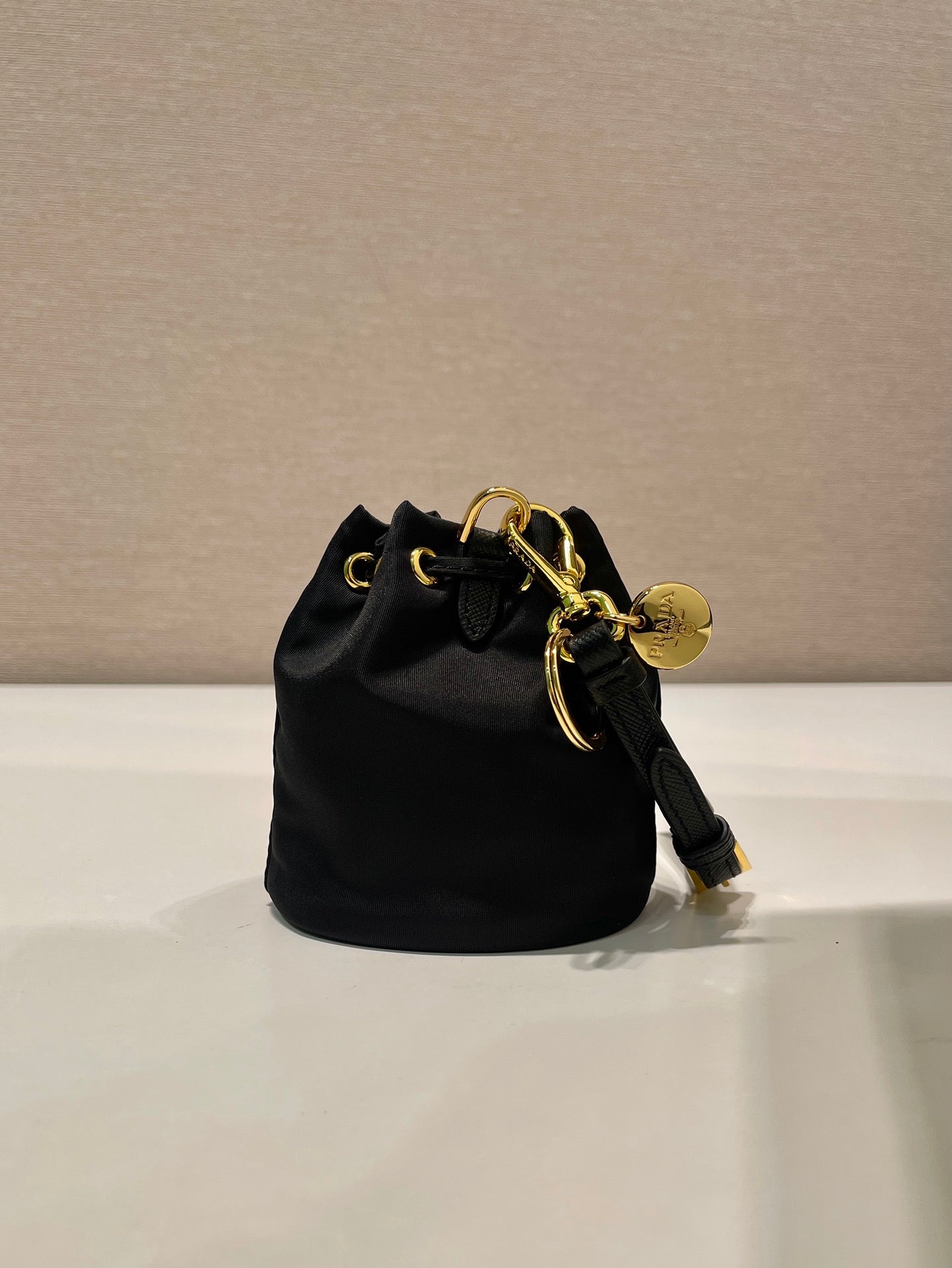 MINI BOLSO BUCKET 10 EN RE-NYLON NEGRO Y CORREA DE PIEL SAFFIANO