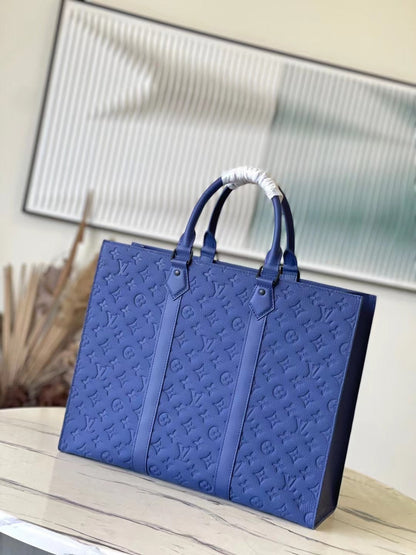 SAC PLAT 24H 41 EN TAURILLON AZUL ZAFIRO CON MONOGRAMA EN RELIEVE