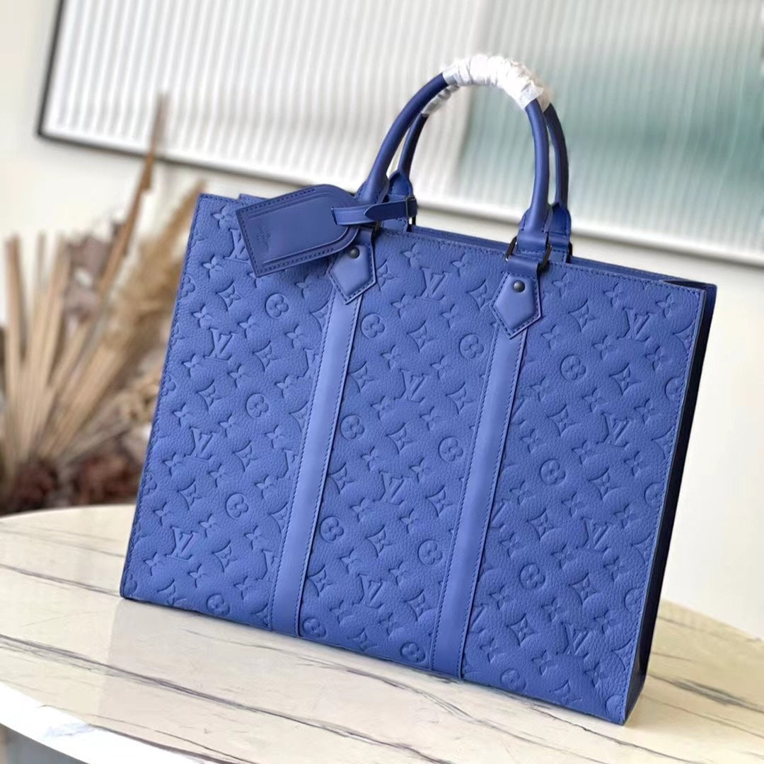 SAC PLAT 24H 41 EN TAURILLON AZUL ZAFIRO CON MONOGRAMA EN RELIEVE